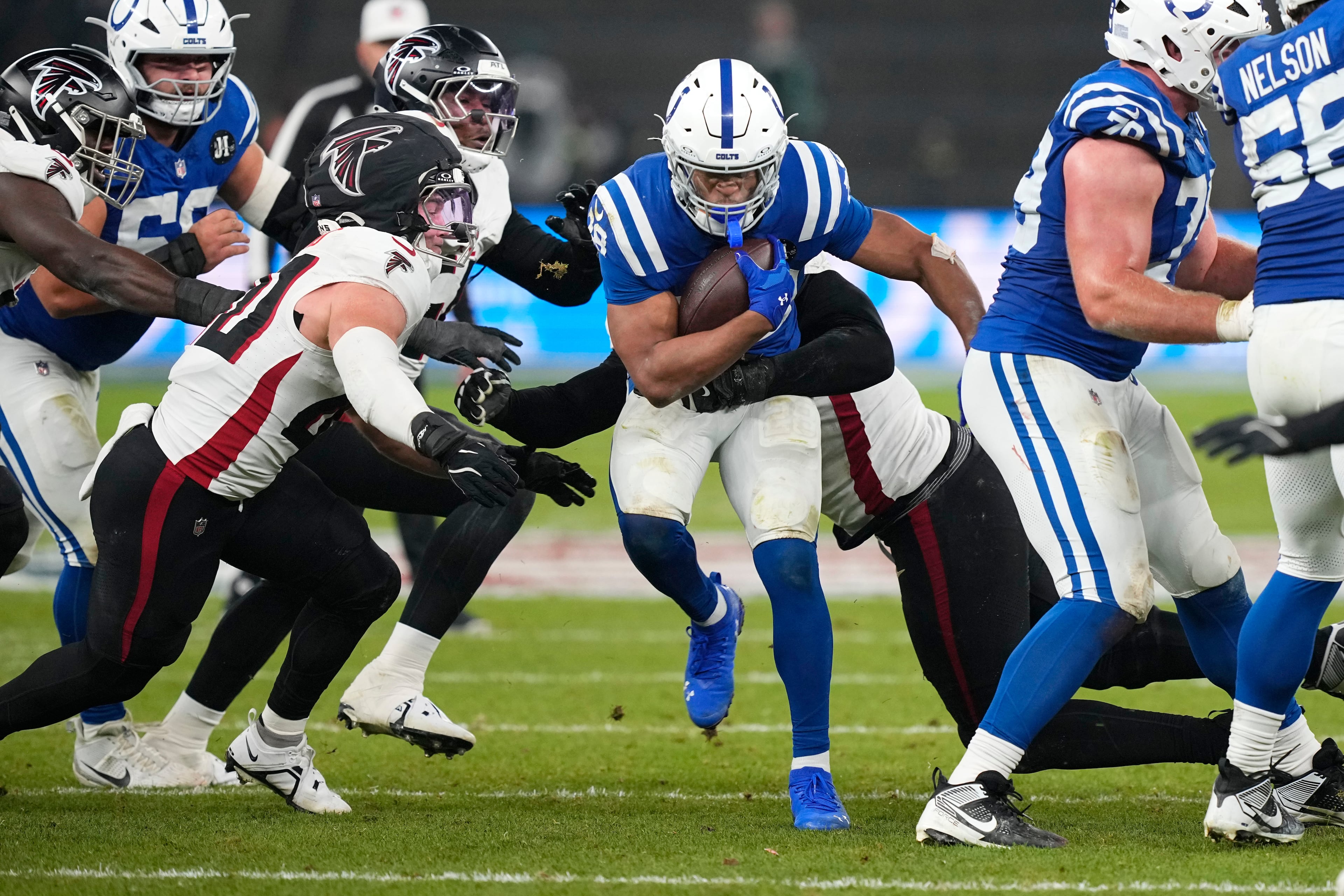 Indianapolis Colts running back Jonathan Taylor (28) runs from Atlanta Falcons linebacker JD Bertrand, left, during the second half of an NFL football game, Sunday, Nov. 9, 2025, in Berlin, Germany. (AP Photo/Martin Meissner)