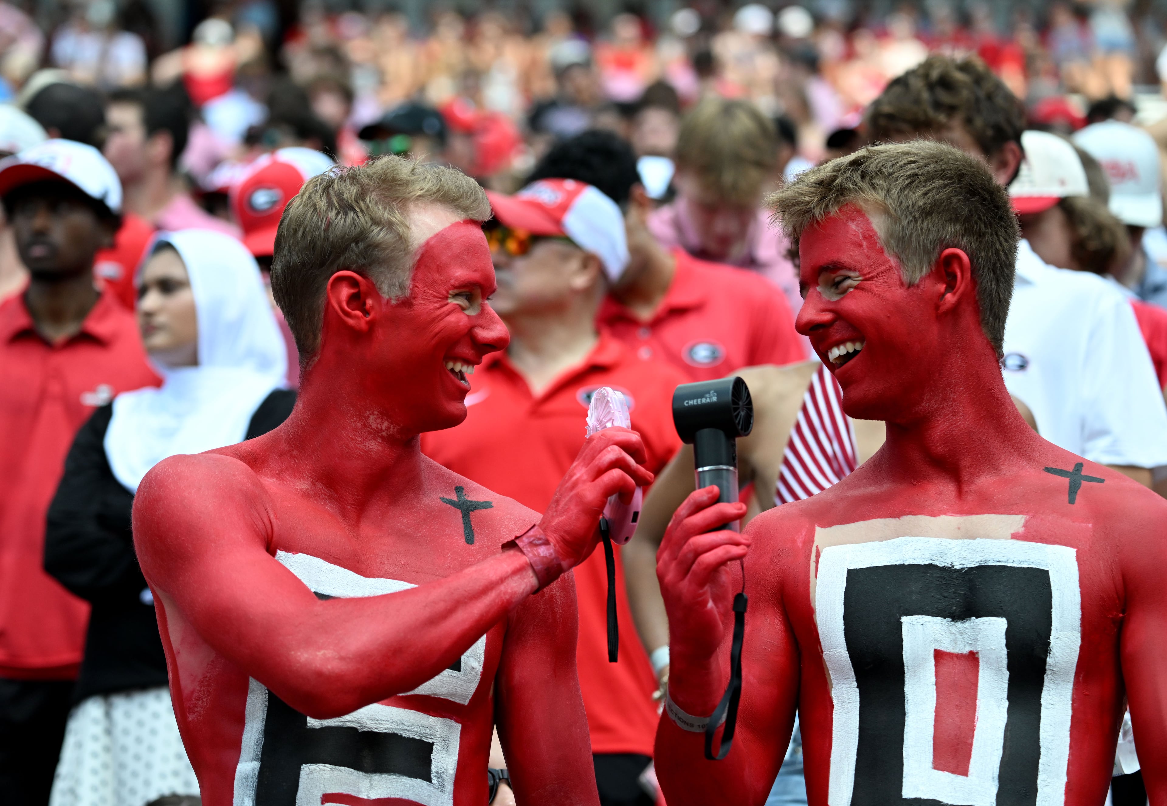 Members of the UGA Paint Line cool down with handheld battery-operated fans before Georgia hosts Tennessee State in its season opener at Sanford Stadium on Saturday, Sept. 5, 2026, in Athens. (Hyosub Shin/AJC)
