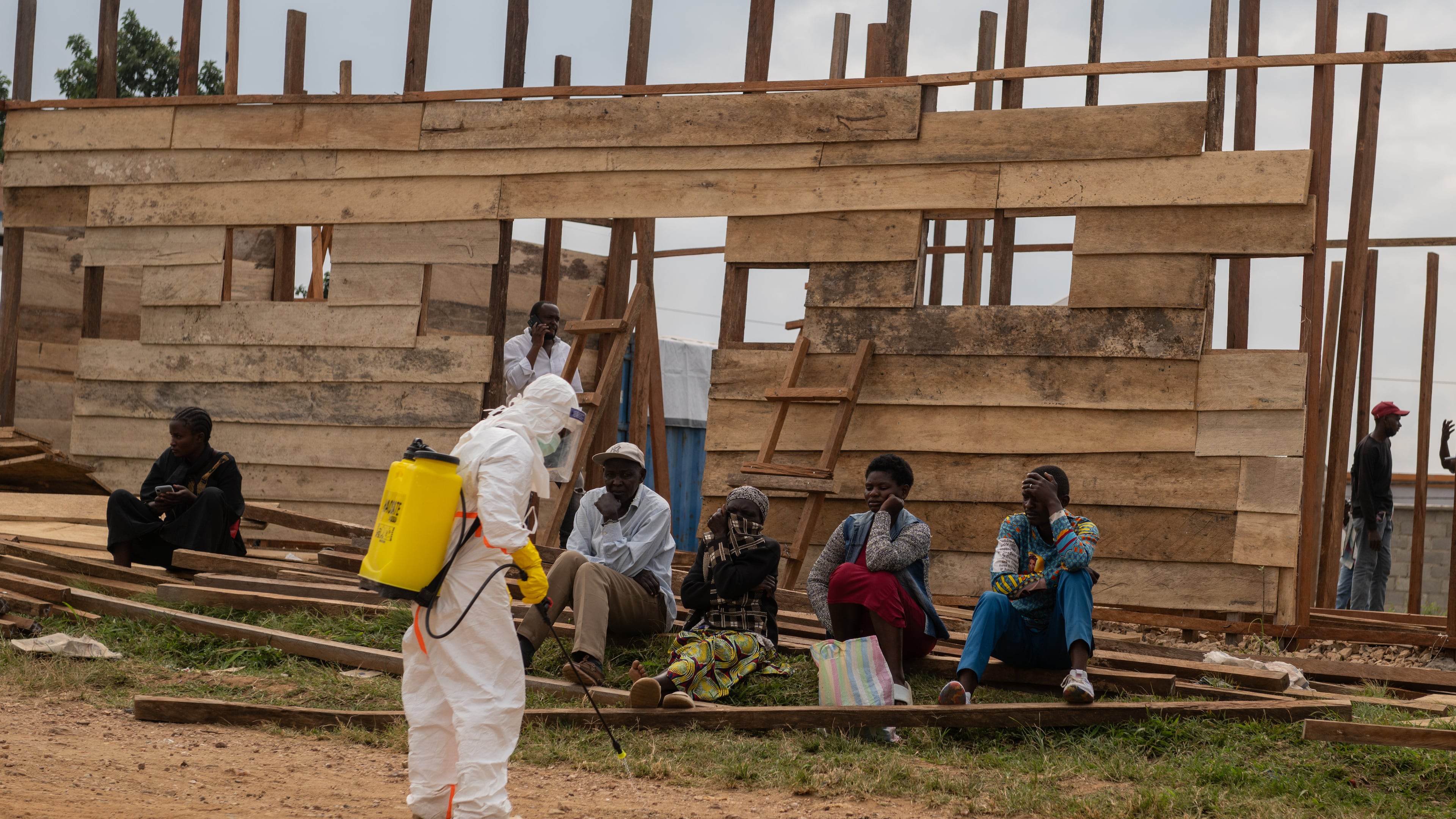 A health worker disinfects the area around a treatment center under construction at the General Hospital in Bunia, Congo, Monday, June 15, 2026. (AP Photo/Moses Sawasawa)