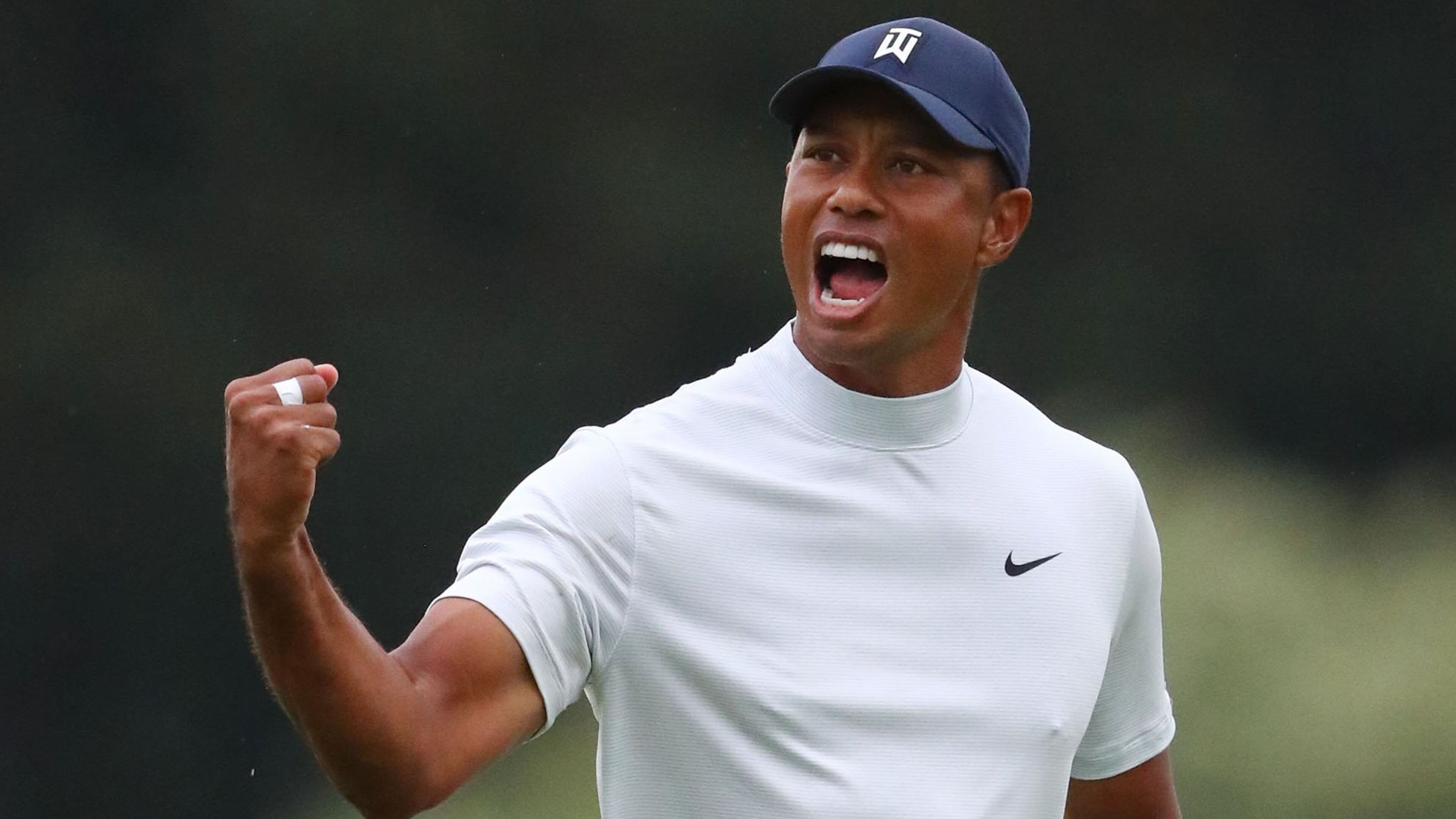 Tiger Woods lets out a roar after his birdie putt on 15 Friday. (Curtis Compton / ccompton@ajc.com)