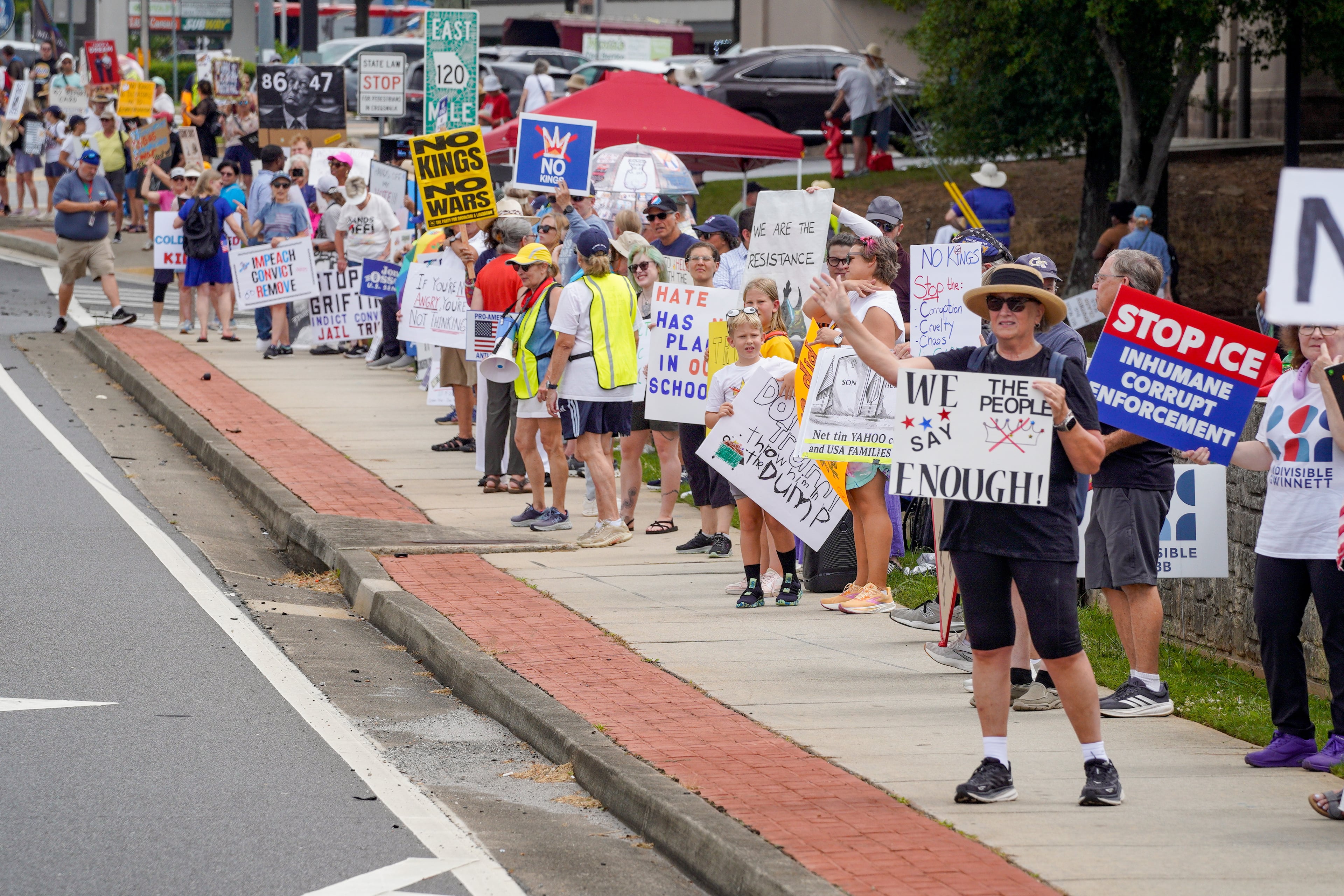 Protestors gather in Marietta while waiting for President Donald Trump to speak at Wheeler High School in Marietta on July 22, 2026. (Ben Hendren for the AJC)