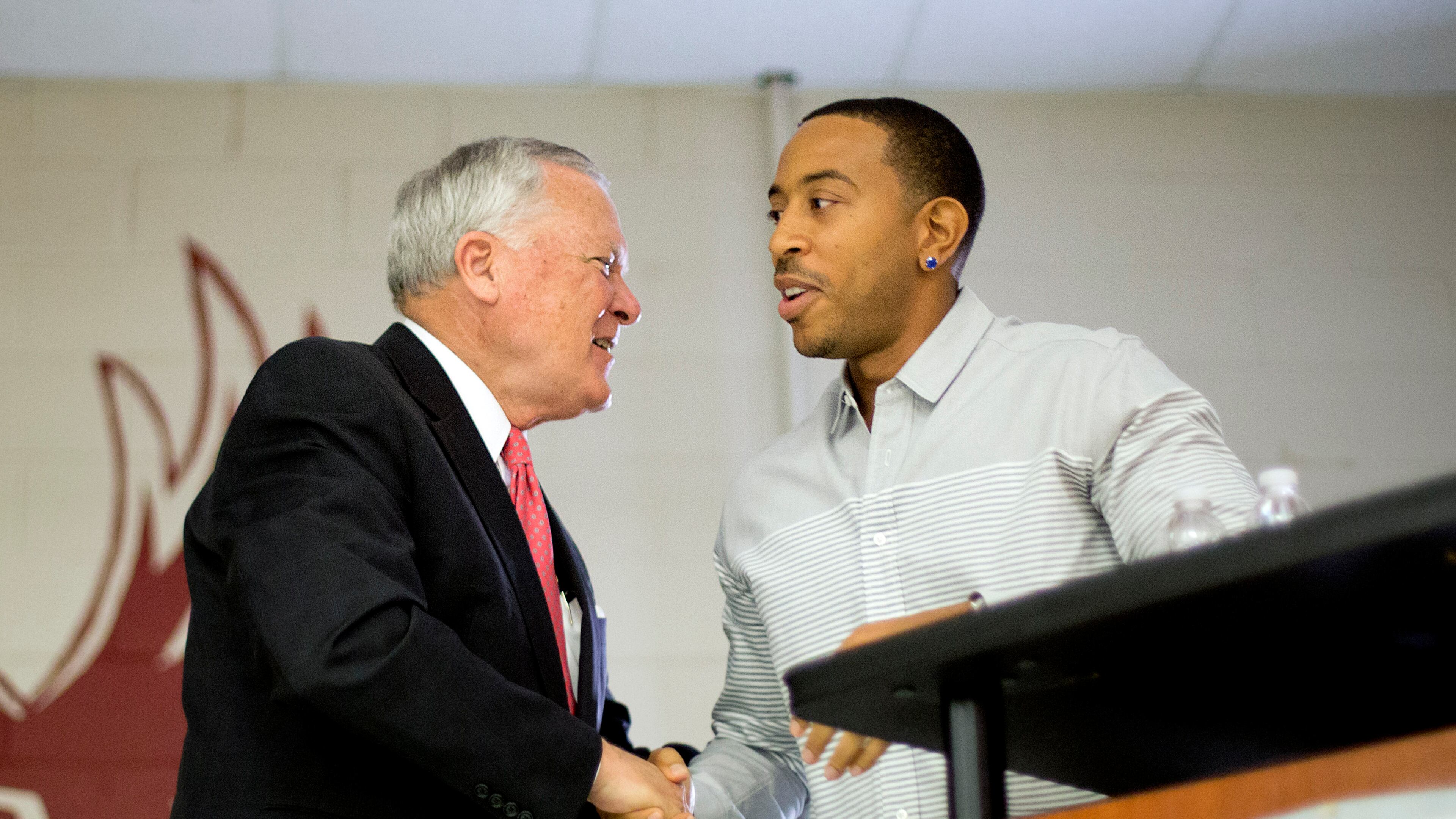 Rapper Ludacris, right, shakes hands with Georgia Gov. Nathan Deal while visiting the charter school Utopian Academy for the Arts, Friday, Sept. 26, 2014, in Riverdale, Ga. Deal and Ludacris may seem like an odd pairing for a campaign event, but the duo was a hit with a cheering crowd of students Friday. Christopher "Ludacris" Bridges has been an outspoken supporter of President Barack Obama, penning a profane song during the 2008 campaign criticizing his opponents. But Deal says he couldn't think of anyone better to inspire students at the event. (AP Photo/David Goldman)