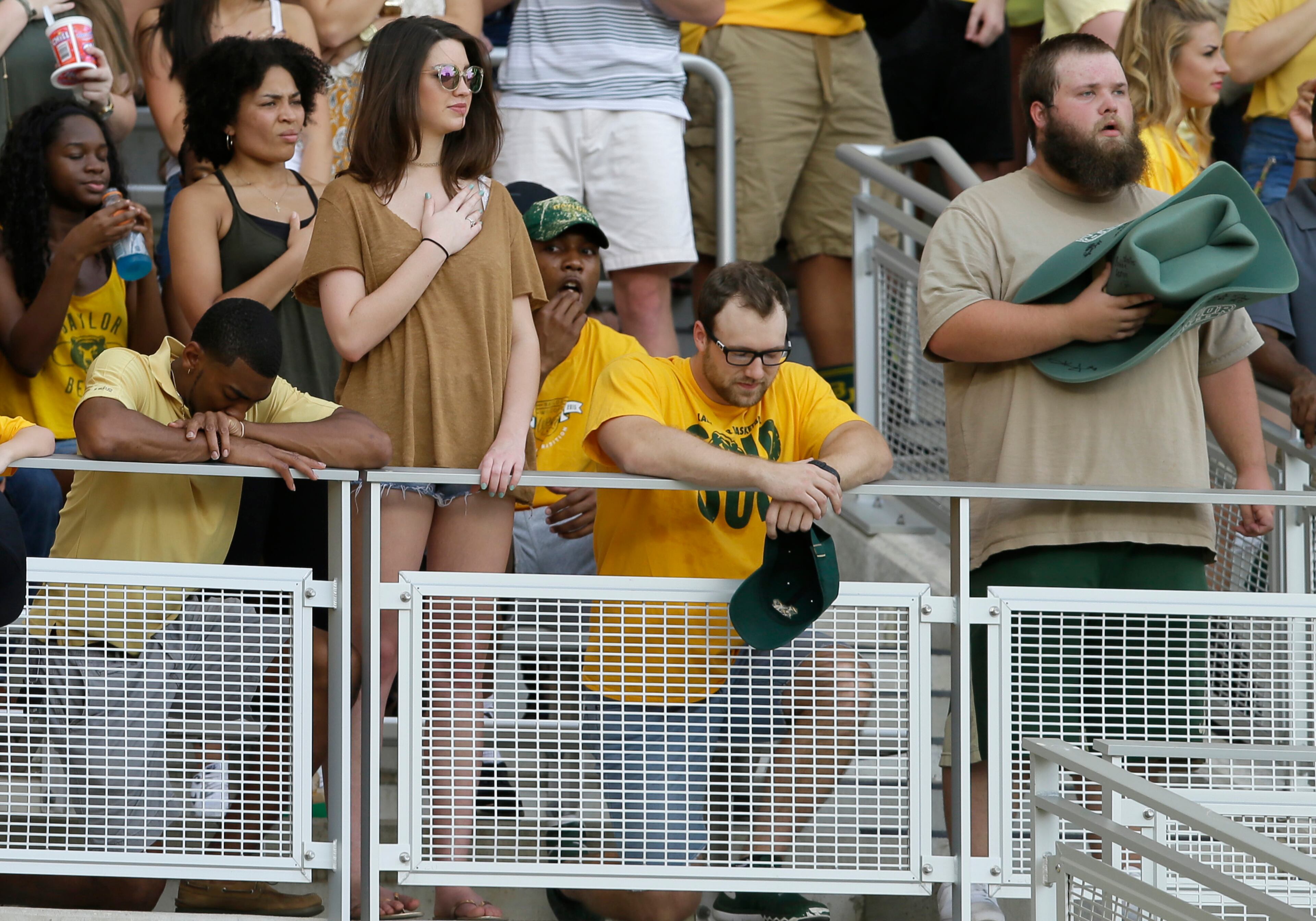 Students in the stands kneel during the national anthem before an NCAA college football game between Oklahoma State and Baylor Saturday, Sept. 24, 2016, in Waco, Texas. (AP Photo/LM Otero)