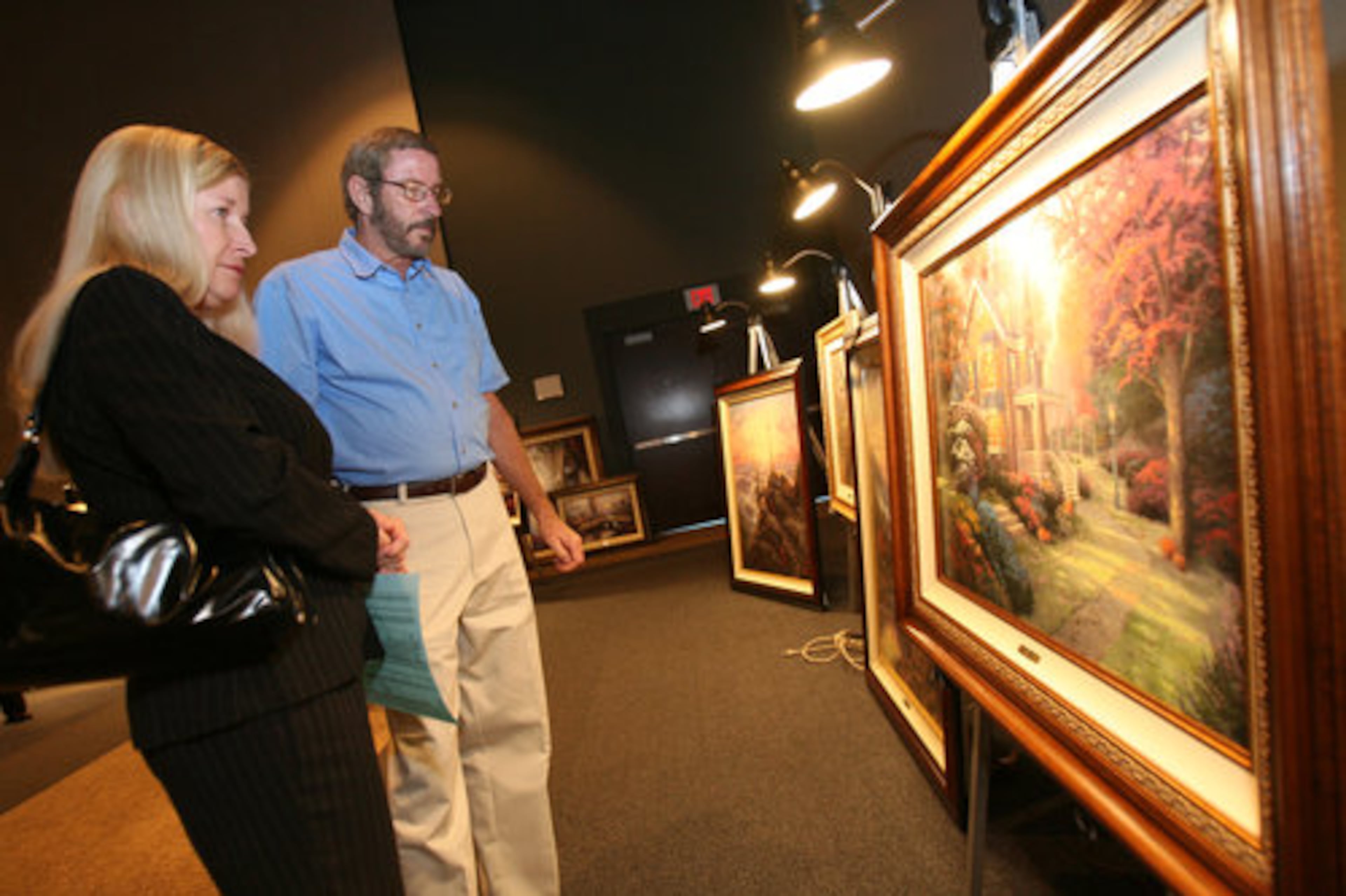 Libby and Tony Brown stop to view the Thomas Kinkade painting "Victorian Autumn" at the Gwinnett Center in 2007.