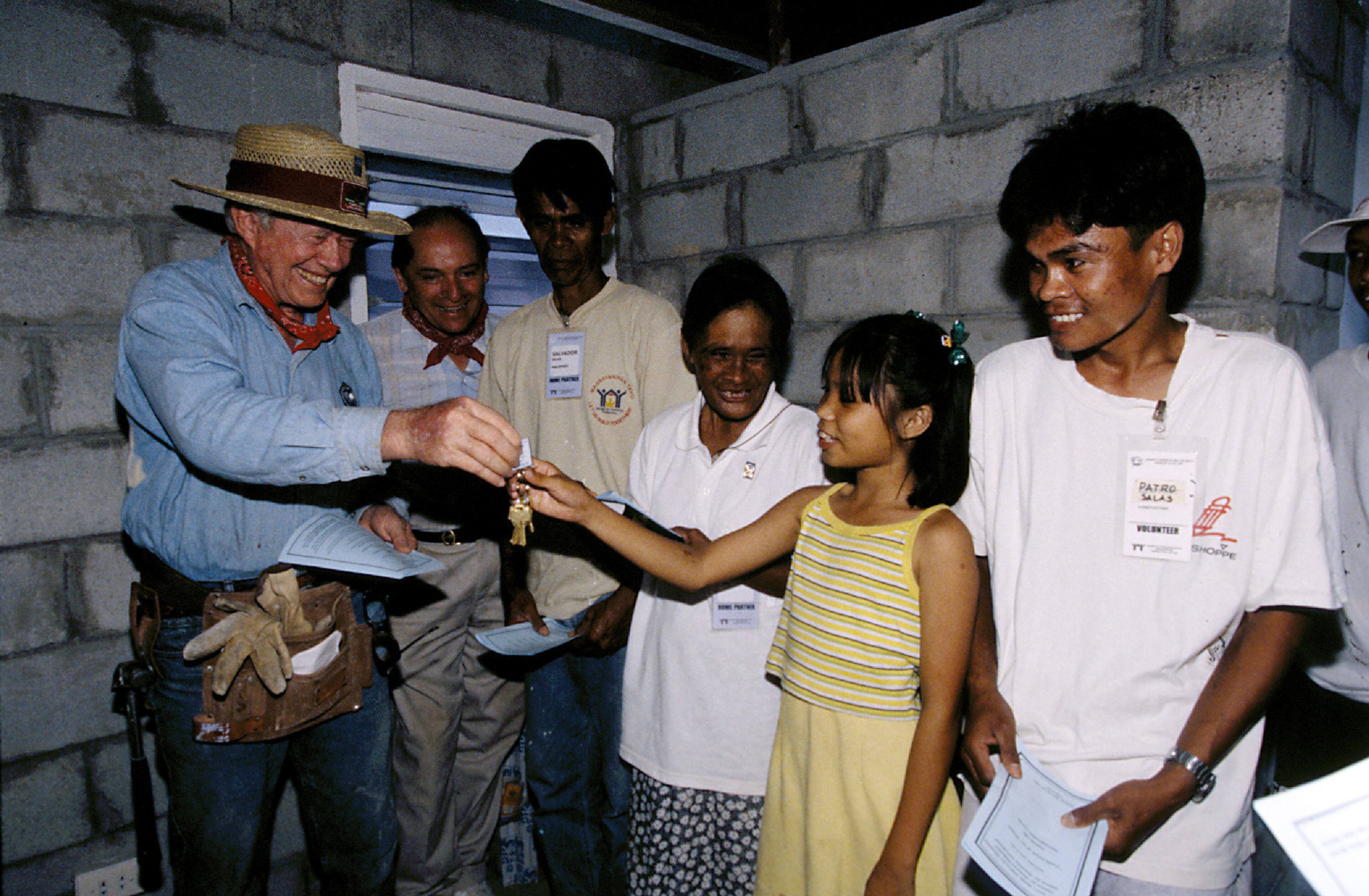 MARAGONDON, PHILIPPINES (3/26/99) --Former President Jimmy Carter gives keys to Habitat homeowner Sunshine Salas at the dedication of her family's new house. (Jimmy Carter Work Project 1999) nodownload ©Habitat for Humanity/Gregg Pachkowski