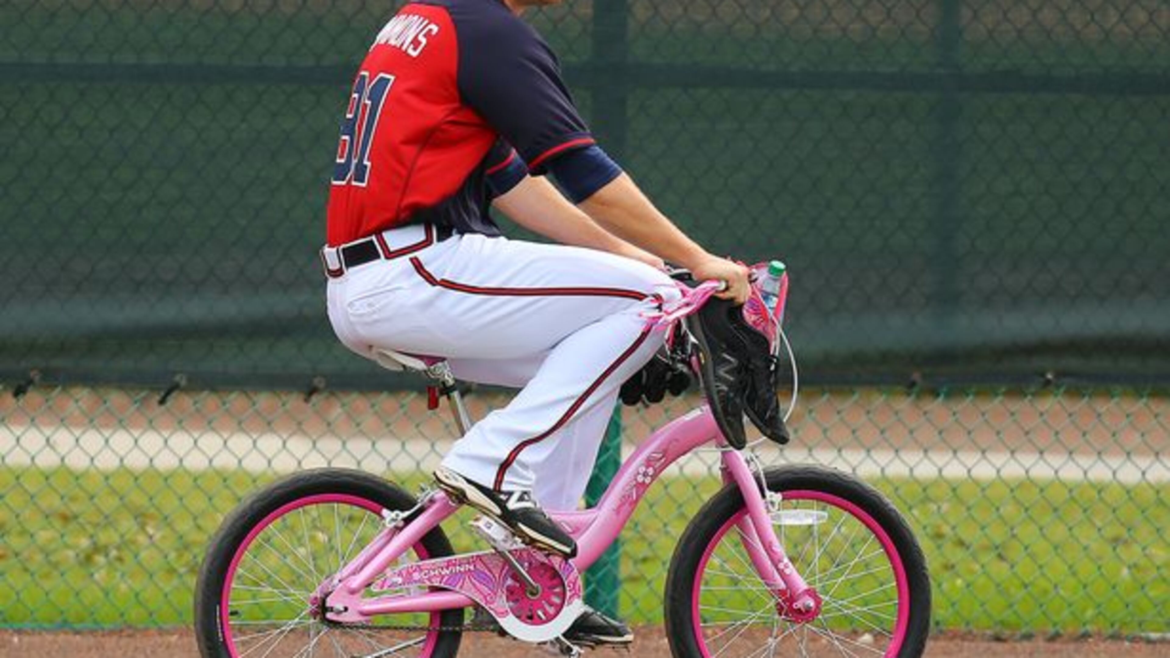 Braves pitching prospect Shae Simmons rides the bike B.J. Upton bought for him as good-natured "punishment" for Simmons catching a ride on a golf cart at a workout last week, a convenience reserved for veterans and staff. (Curtis Compton photo/AJC)