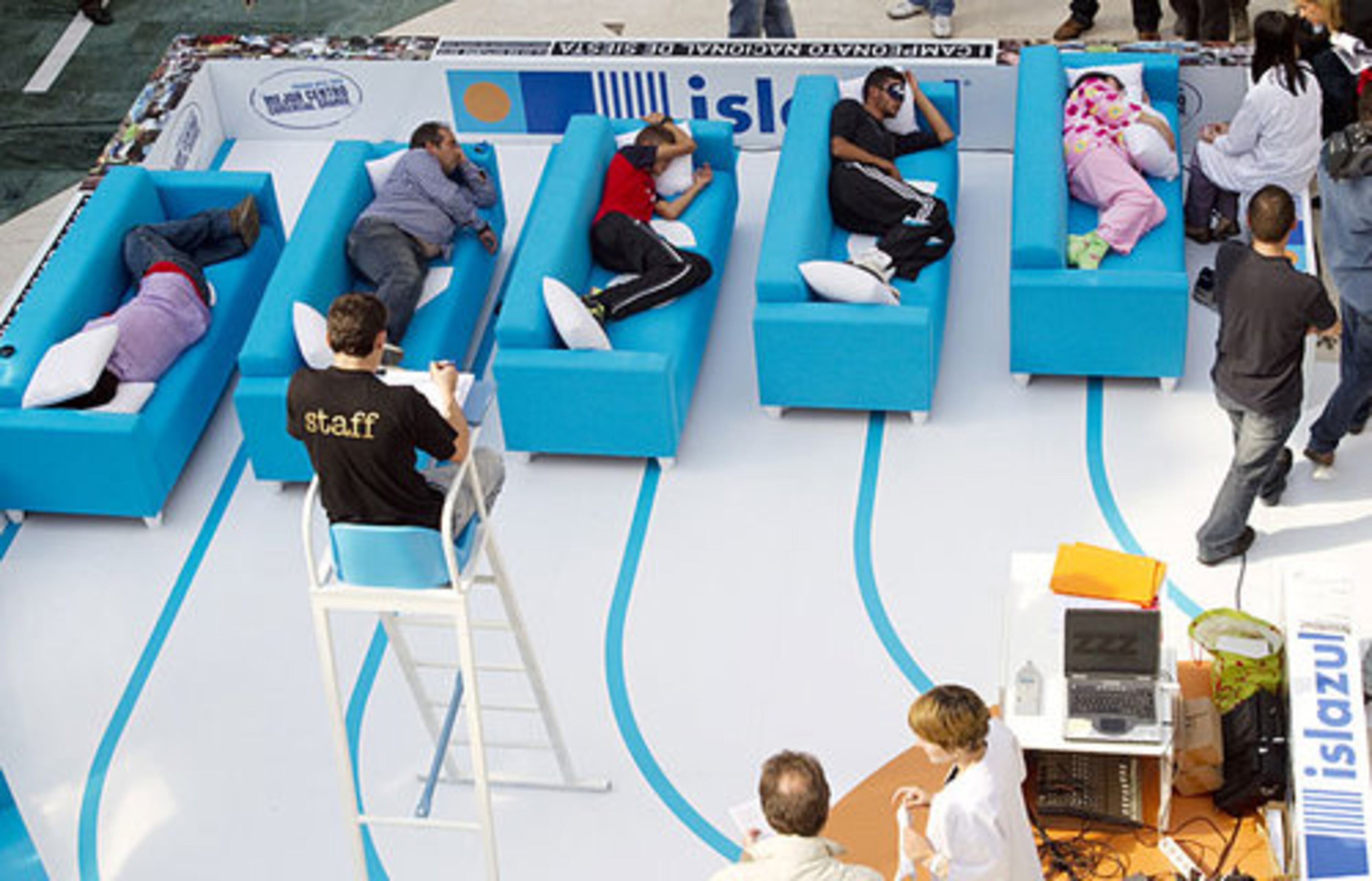 A judge watches as people sleep a siesta during the first Siesta Championship in Madrid, Thursday, Oct. 14, 2010.