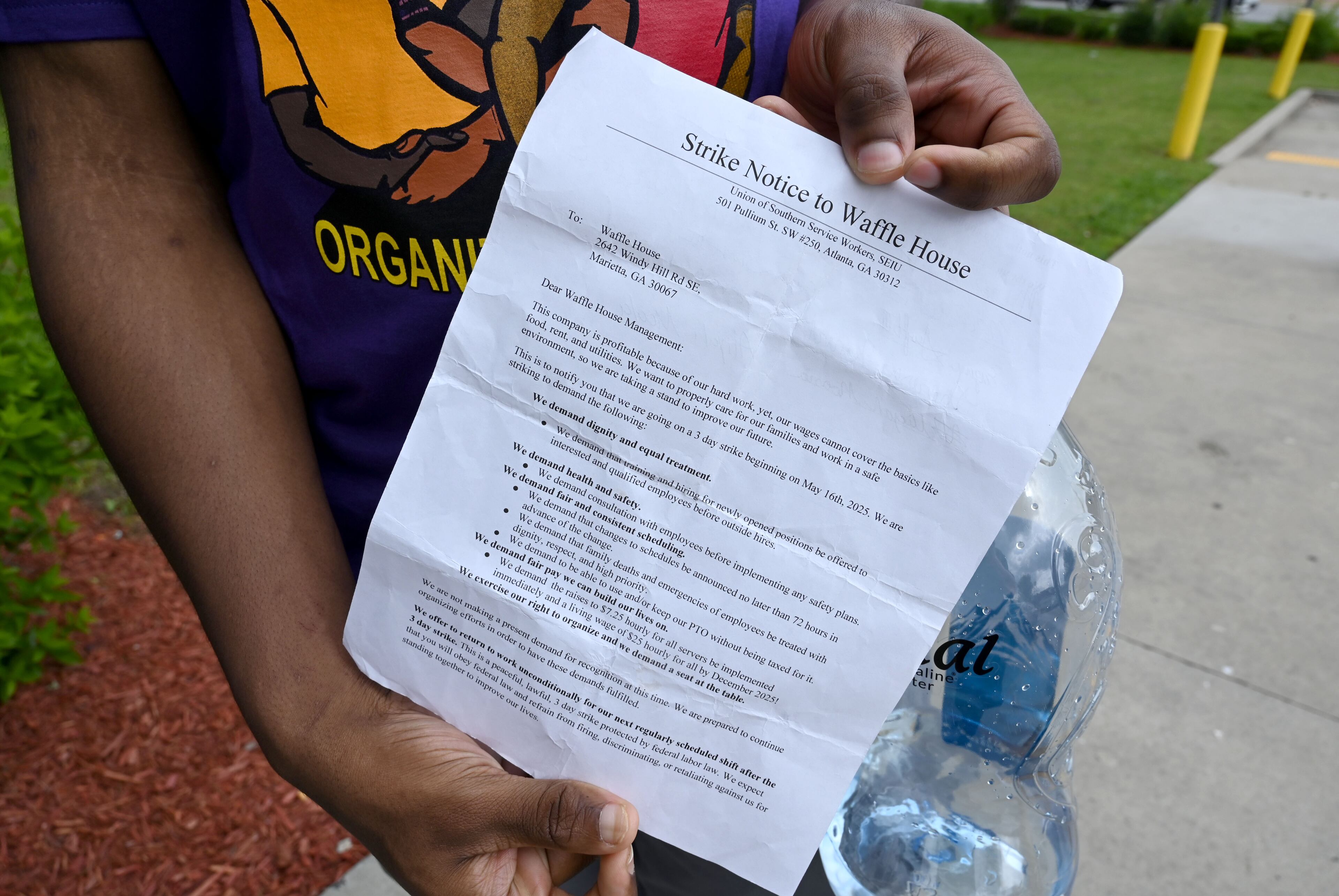 Waffle House employee Mark Burgrom holds a strike notice letter before he delivers it to management. Burgrom works the third shift, which covers the late night and early morning. He said Waffle House policy changes in recent years have made it more difficult to make tips during those hours. (Hyosub Shin/AJC)