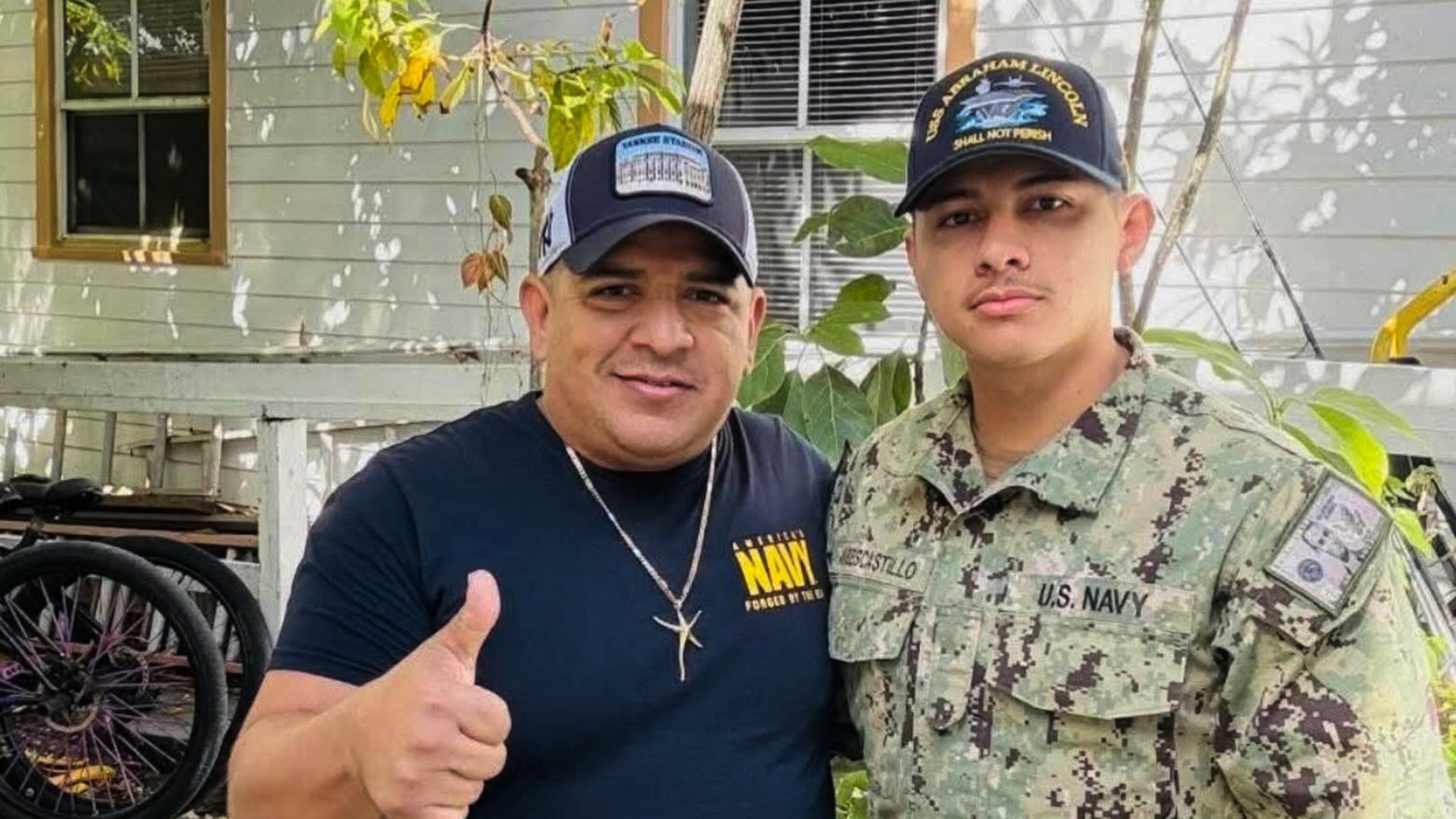 In this photo courtesy of Katherine Delgado shows her step-father Luis Manuel Aviles, left, and her brother Joshua Aviles stand outside their home in Oct. 2025, shortly before Joshua deployed on the USS Lincoln the following month in Key West, Fla. (Katherine Delgado via the AP)