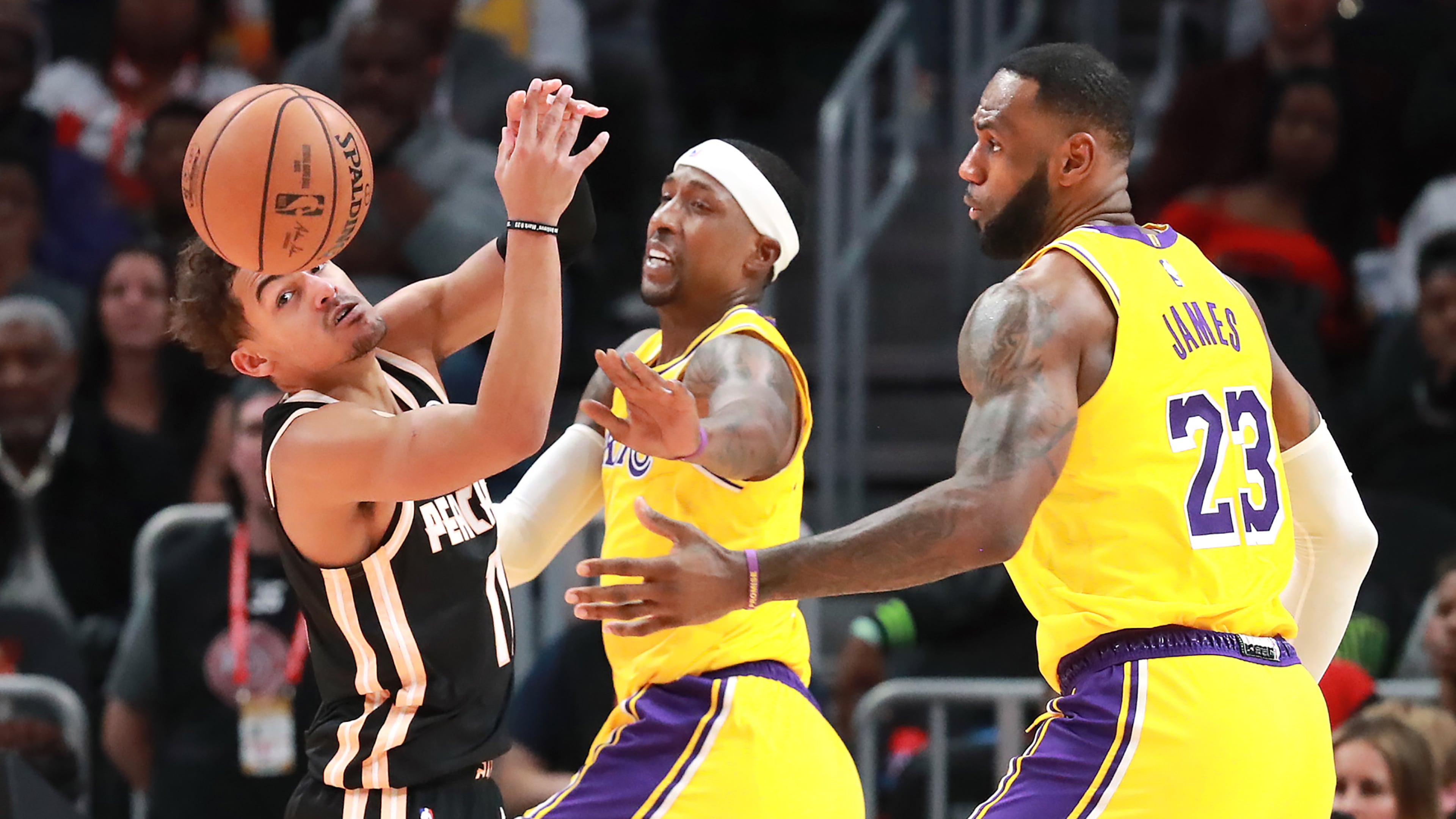 Hawks guard Trae Young (from left) loses the battle for the ball under the basket with Lakers Kentavious Caldwell-Pope and LeBron James during the second half Sunday, Dec. 15, 2019, at State Farm Arena in Atlanta.