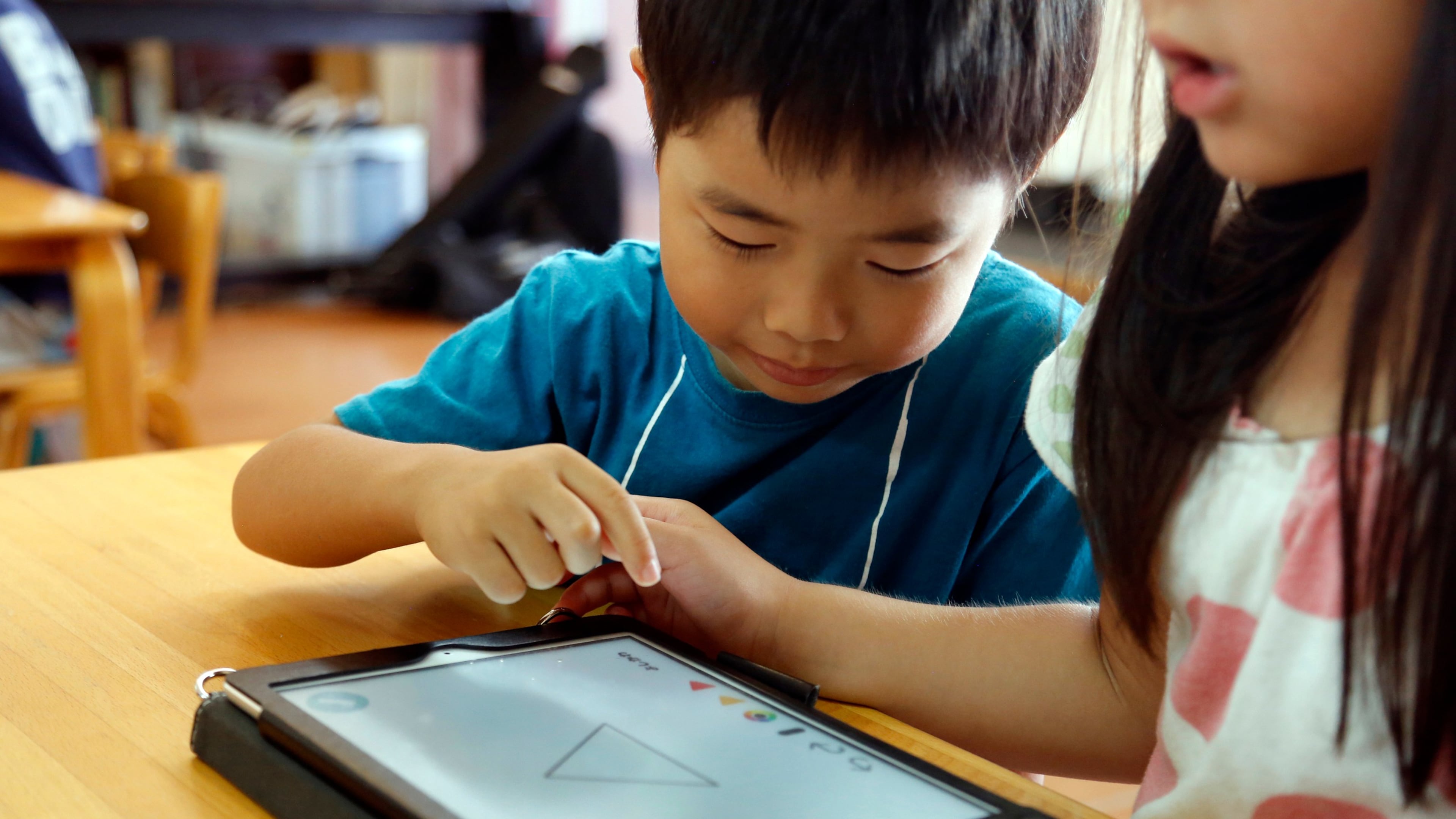 FILE - Children work on a digital program at Coby Preschool in Yoshikawa, suburban Tokyo, July 12, 2018. (AP Photo/Yuri Kageyama, File)