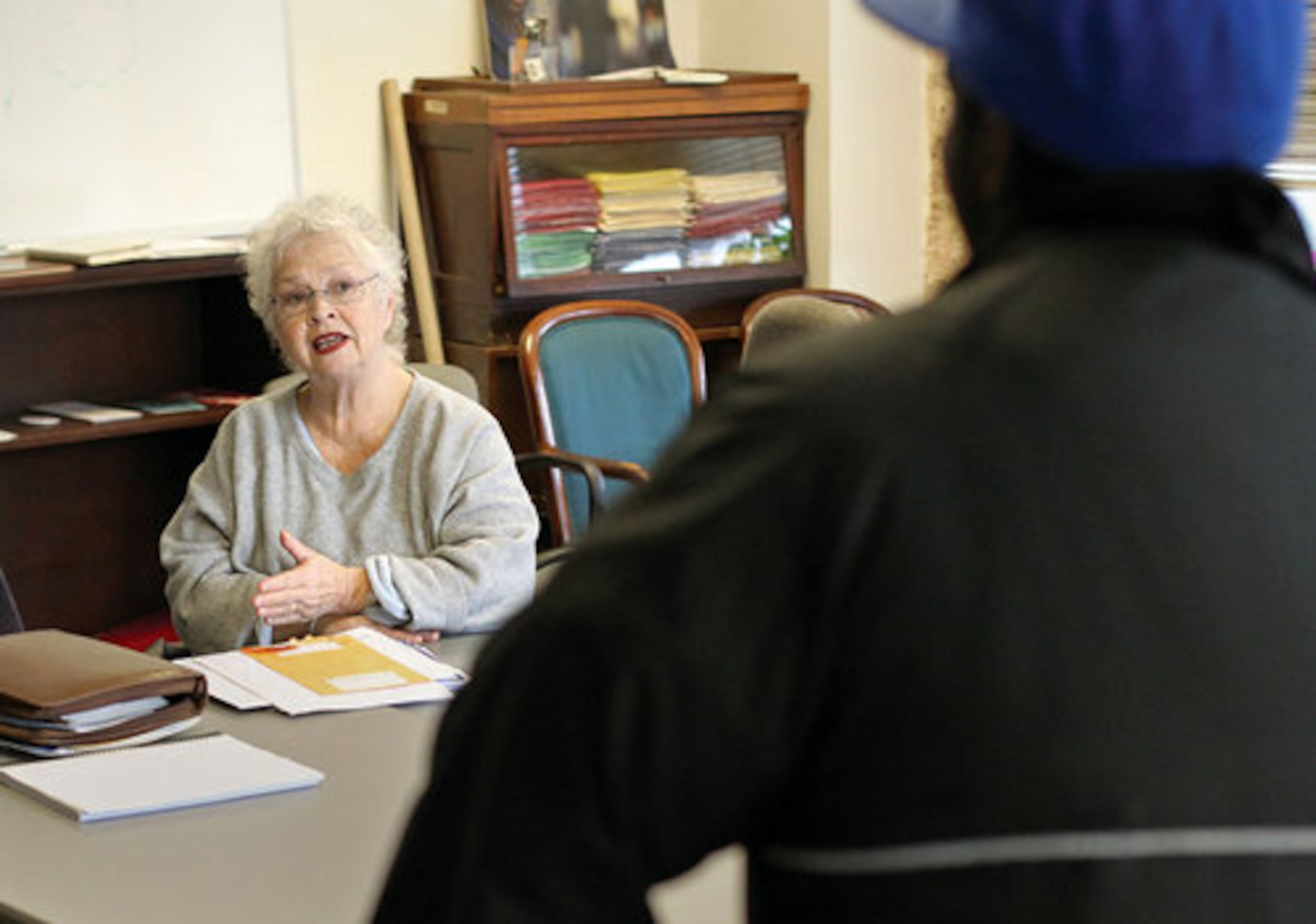 Executive Director Anita Beaty, facing, talks with Alex Jackson, 25, right, during a meeting after he was evicted after for fighting. The shelter has stern rules about fighting and does not allow weapons inside the building.
