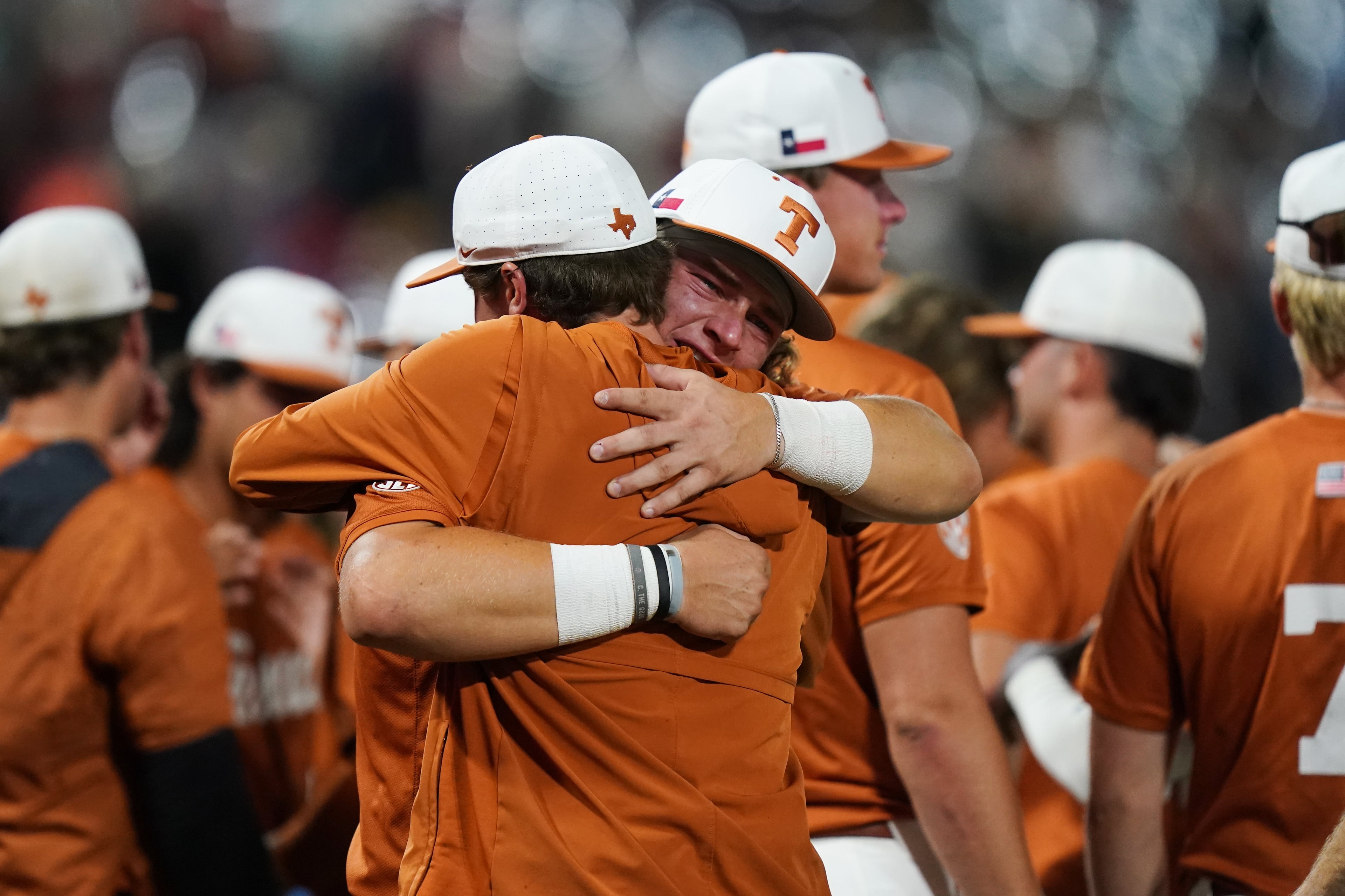 Texas catcher Carson Tinney (8) is comforted by teammates after an NCAA baseball College World Series elimination game against Georgia, Tuesday, June 16, 2026 in Omaha, Neb. Georgia won 2-0. (AP Photo/Vera Nieuwenhuis)