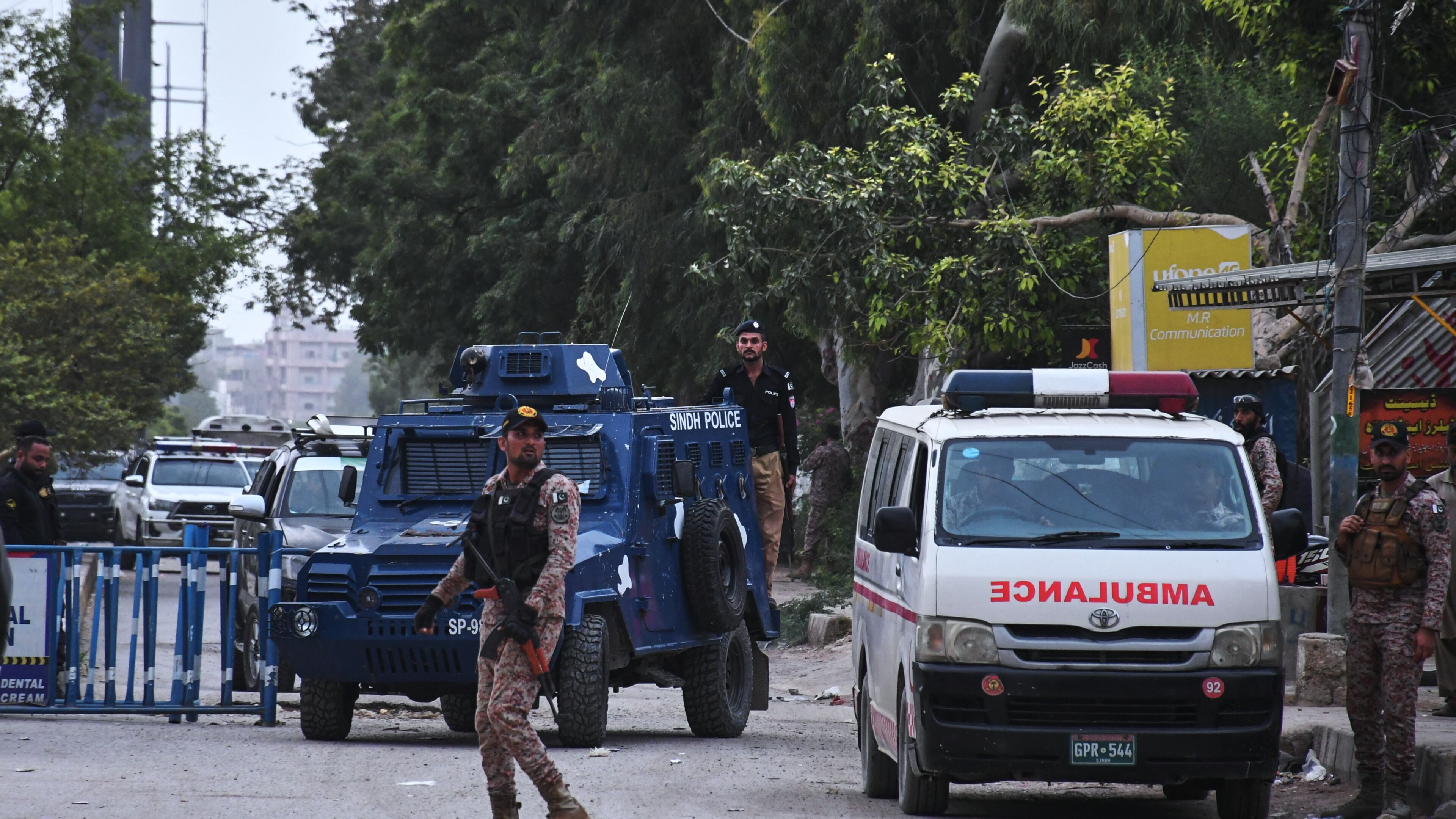 Paramilitary soldiers and police officers stand guard on a road cordoned off near the site of a militant attack at the provincial headquarters of the paramilitary Pakistan Rangers in Karachi, Pakistan, Sunday, June 28, 2026. (AP Photo/Ali Raza)