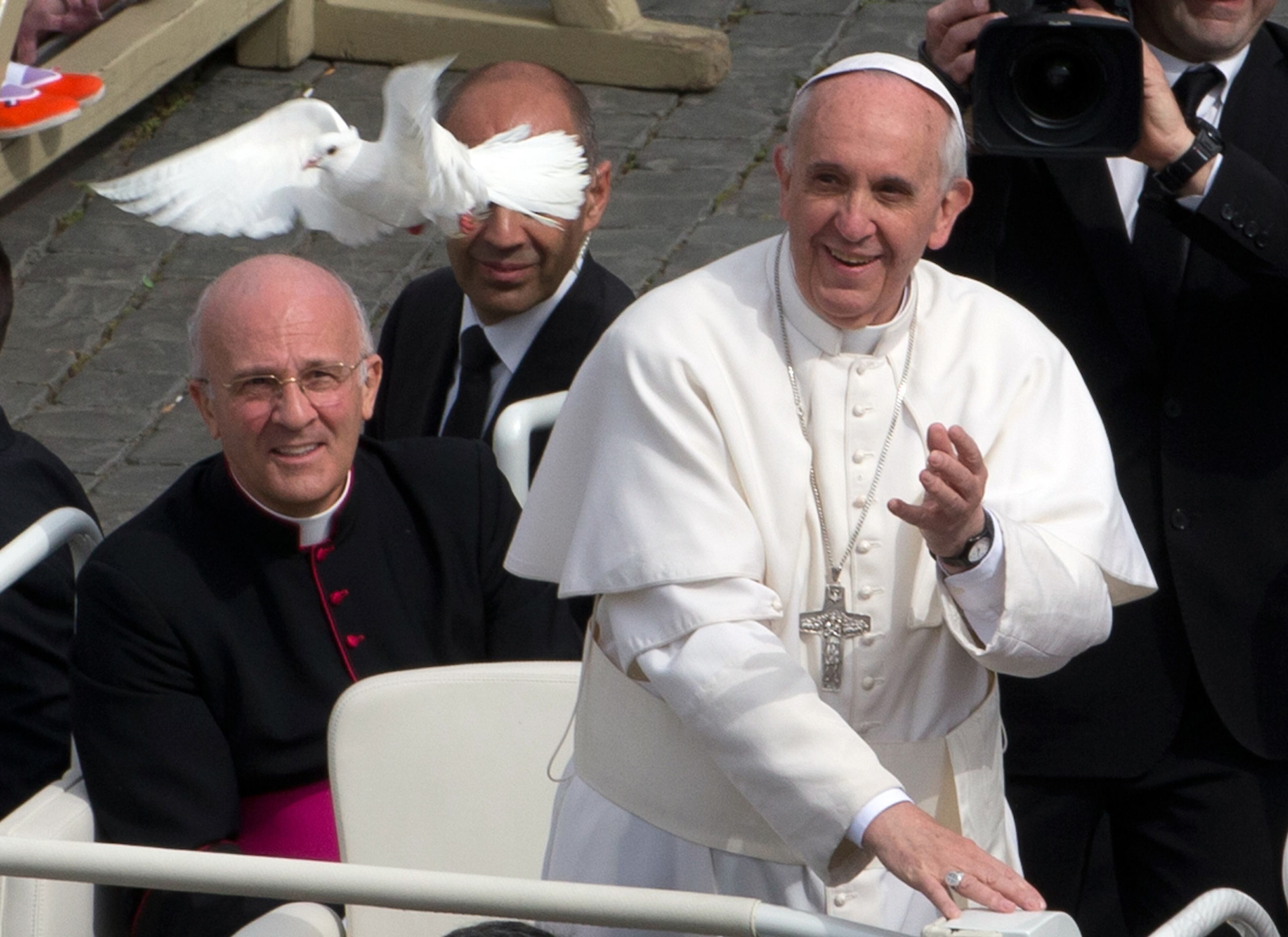 Pope Francis looks at a dove fly away after he freed it from a cage during his weekly general audience in St. Peter Square at the Vatican, Wednesday, May 15, 2013. As Francis toured the square in his open-topped popemobile at his Wednesday audience with the public, someone at the edge of the crowd thrust a white bird cage at him. Looking puzzled, his security detail took the cage, containing a pair of white doves, and handed it to Francis. Without hesitation, the pope opened the cage door, thrust a hand inside and extracted one dove, and with a flick of his hand, sent the bird flying over the square. (AP Photo/Alessandra Tarantino)
