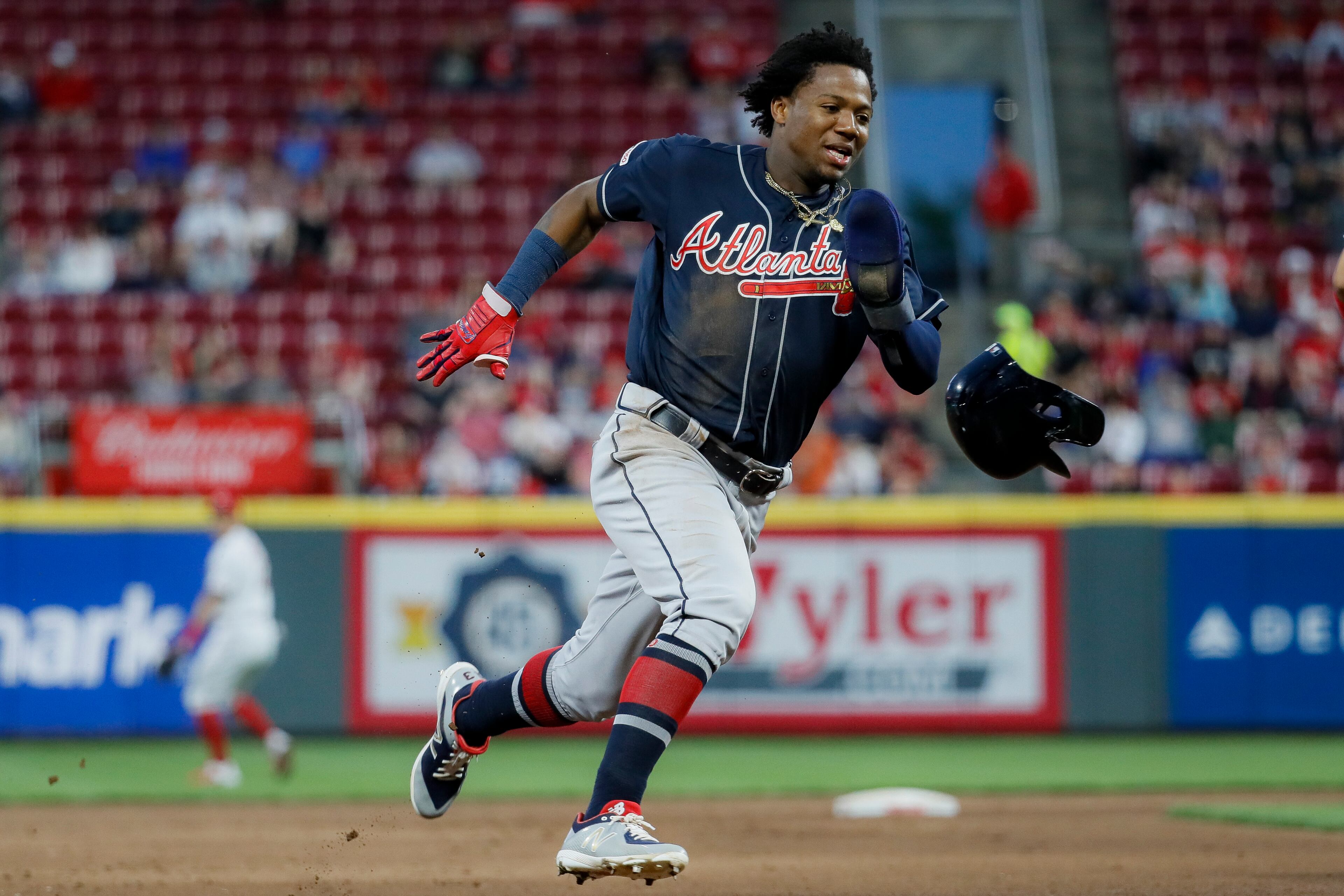 Atlanta Braves' Ronald Acuna Jr. runs home to score on an error by Cincinnati Reds right fielder Yasiel Puig (66) in the fifth inning of a baseball game, Wednesday, April 24, 2019, in Cincinnati. (AP Photo/John Minchillo)