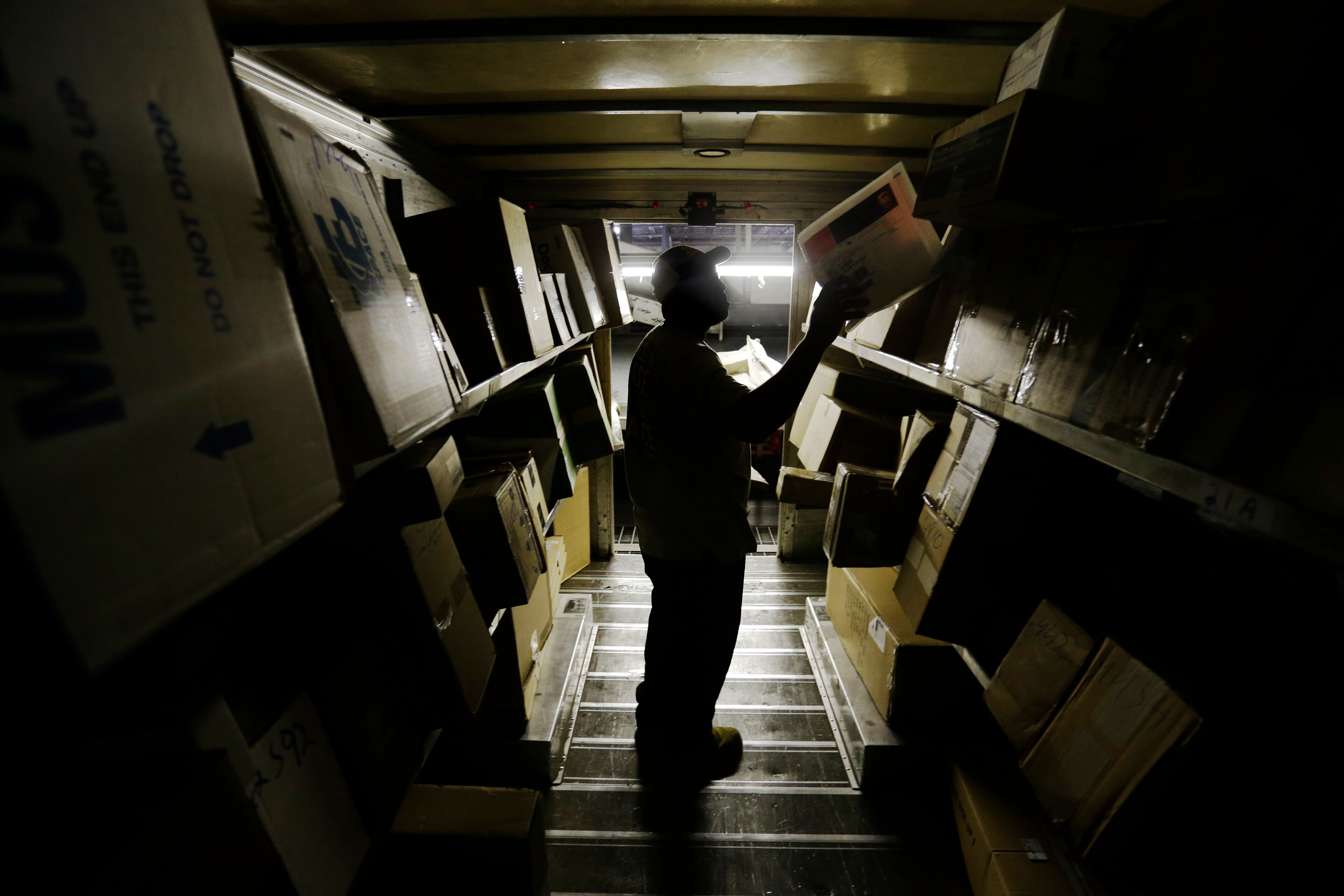 In this June 20, 2014 photo, United Parcel Service pre-loader Etonka Bowden, loads packages on to a truck before morning deliveries from the company's sorting facility in Roswell, Ga. (AP Photo/David Goldman)