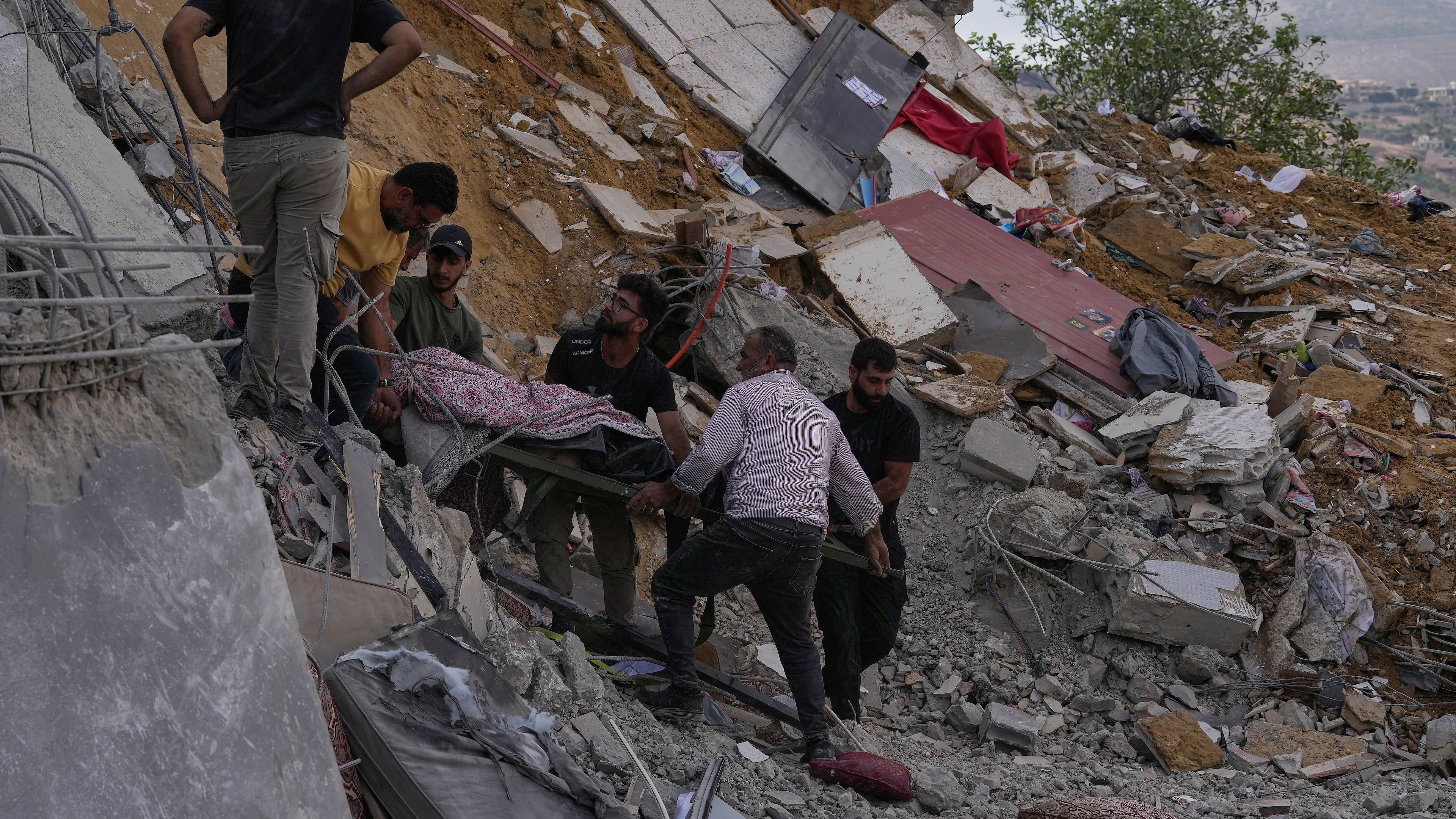 People carry a body of a person who was killed at a house that was hit by an Israeli airstrike in Arab Salim village, southern Lebanon, Sunday, Sept. 6, 2026. (AP Photo/Mohammed Zaatari)