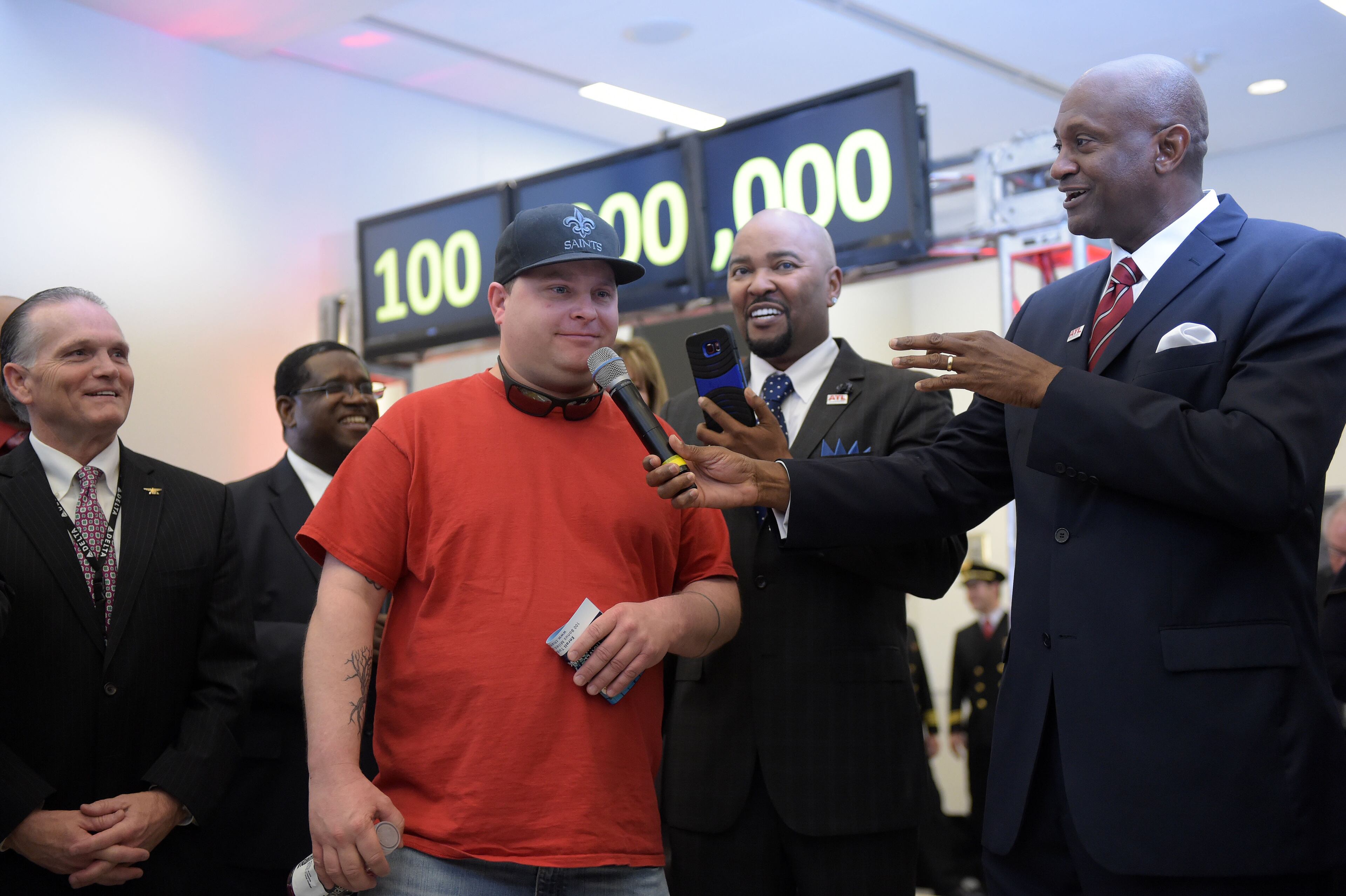 Passenger Larry Kendrick give remarks during the ceremony. Hartsfield-Jackson International Airport awarded its 100 millionth passenger for 2015 with prizes including a new car, two free airline tickets and a small crowd of officials and television cameras early Sunday December 27, 2015. The Atlanta airport, "the world's busiest" is the first airport in the world to handle 100 million passengers in a year. "It's our commitment that we maintain our position as the world's most traveled airport," said Atlanta Mayor Kasim Reed during remarks at the airport before the flight arrived Sunday morning. The winner, a man from Biloxi named Larry Kendrick who arrived at the airport in blue jeans, an orange t-shirt and a baseball cap, was surprised to learn upon landing that he had been selected as the 100 millionth passenger. KENT D. JOHNSON/ kdjohnson@ajc.com