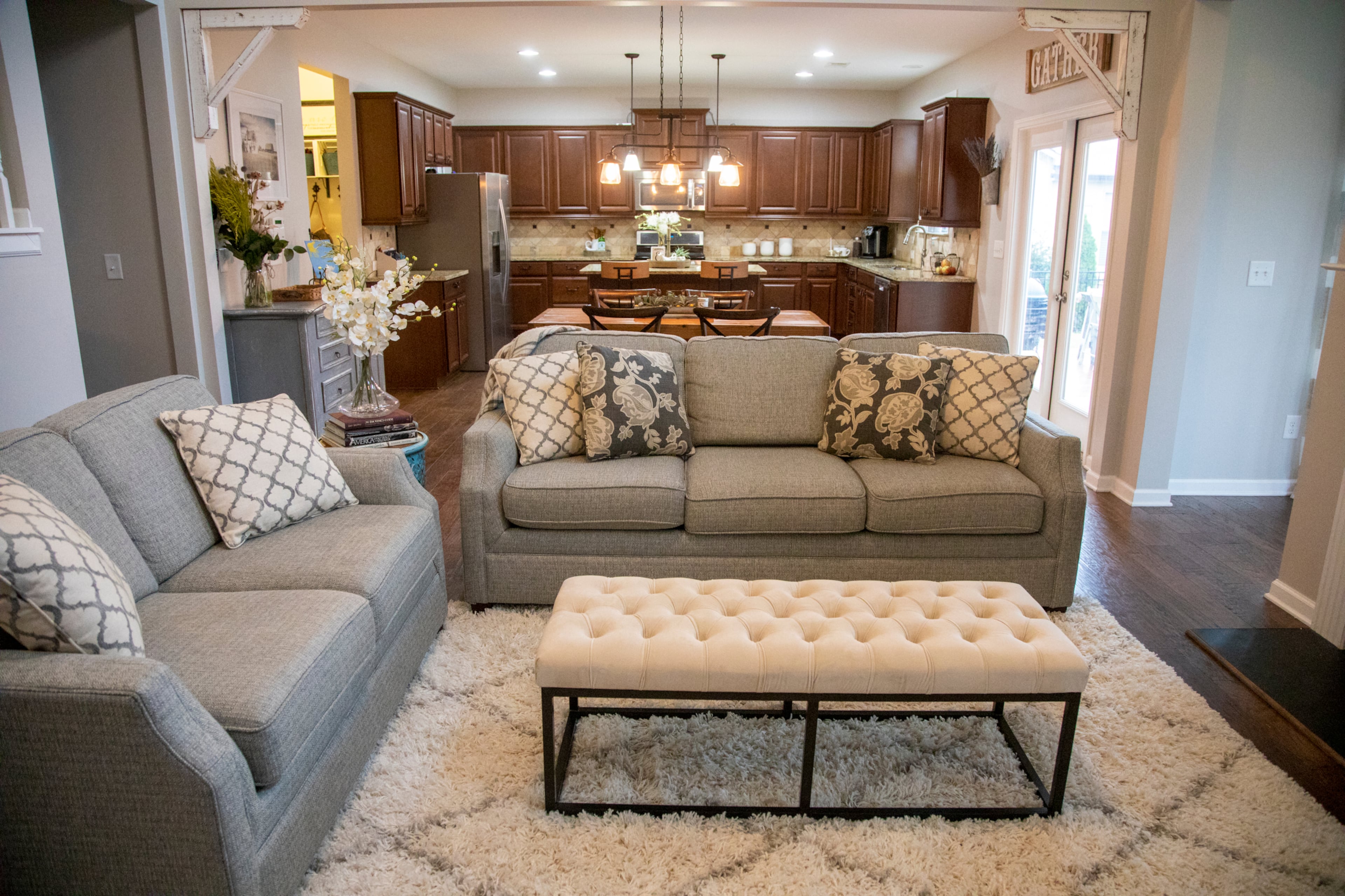 Painting the originally beige walls Sherwin-Williams' Agreeable Gray warmed up the open living spaces, says homeowner Leah Elliott. The couches were purchased at Woodstock Furniture & Mattress Outlet, and just beyond them, a gray cabinet purchased a consignment shop now holds craft supplies.