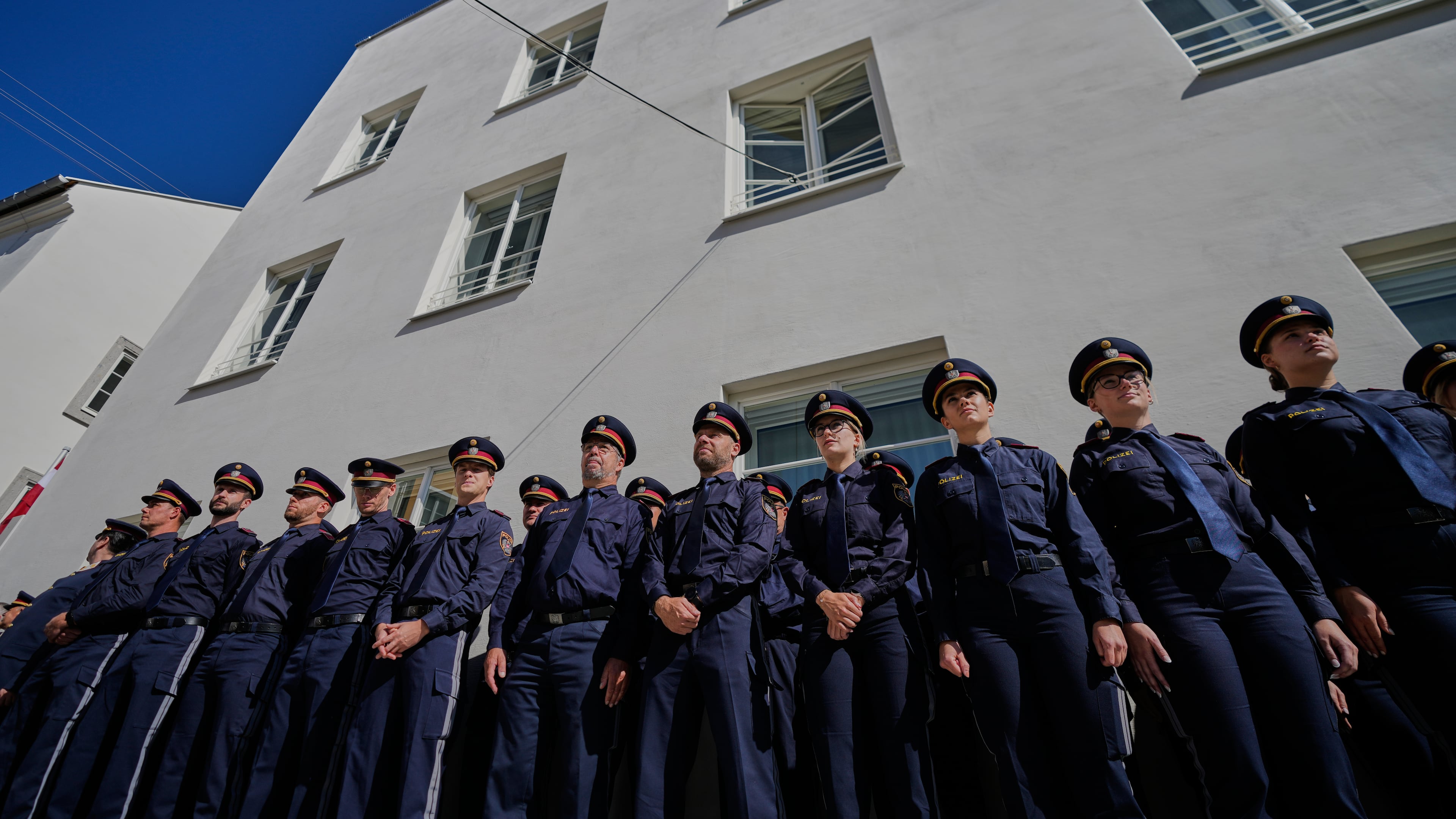Austrian police officers stand in front of a new police station which is located in Adolf Hitler's birth house in Braunau am Inn, Austria, Wednesday, July 22, 2026. (AP Photo/Matthias Schrader)