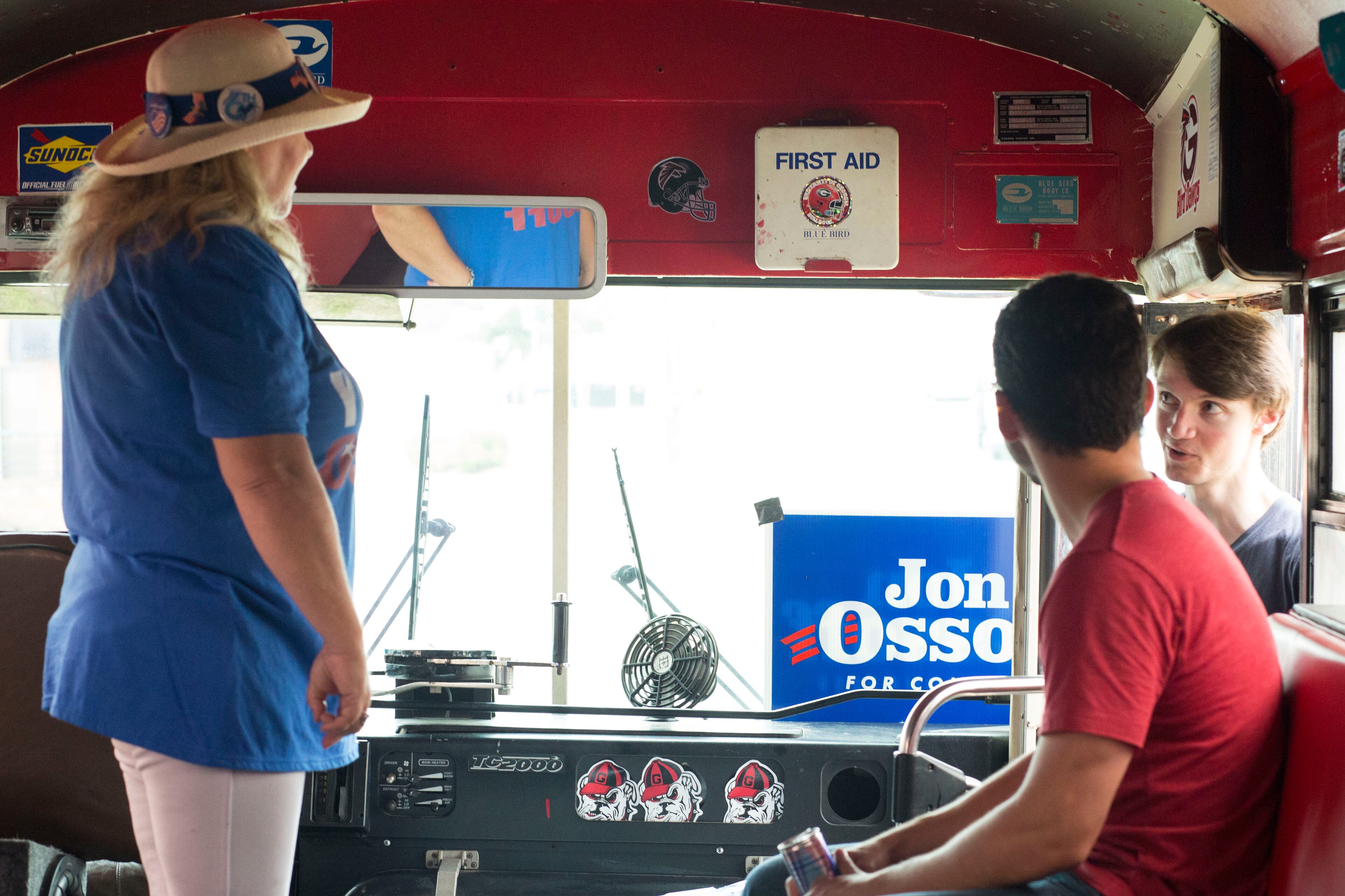 Mary Glider (left), Preslav Mantchev (front right) and Sullivan Peterson-Quin (back right), converse about congressional candidate Jon Ossoff on an Ossoff-themed bus. Chad Rhym/ Chad.Rhym@ajc.com