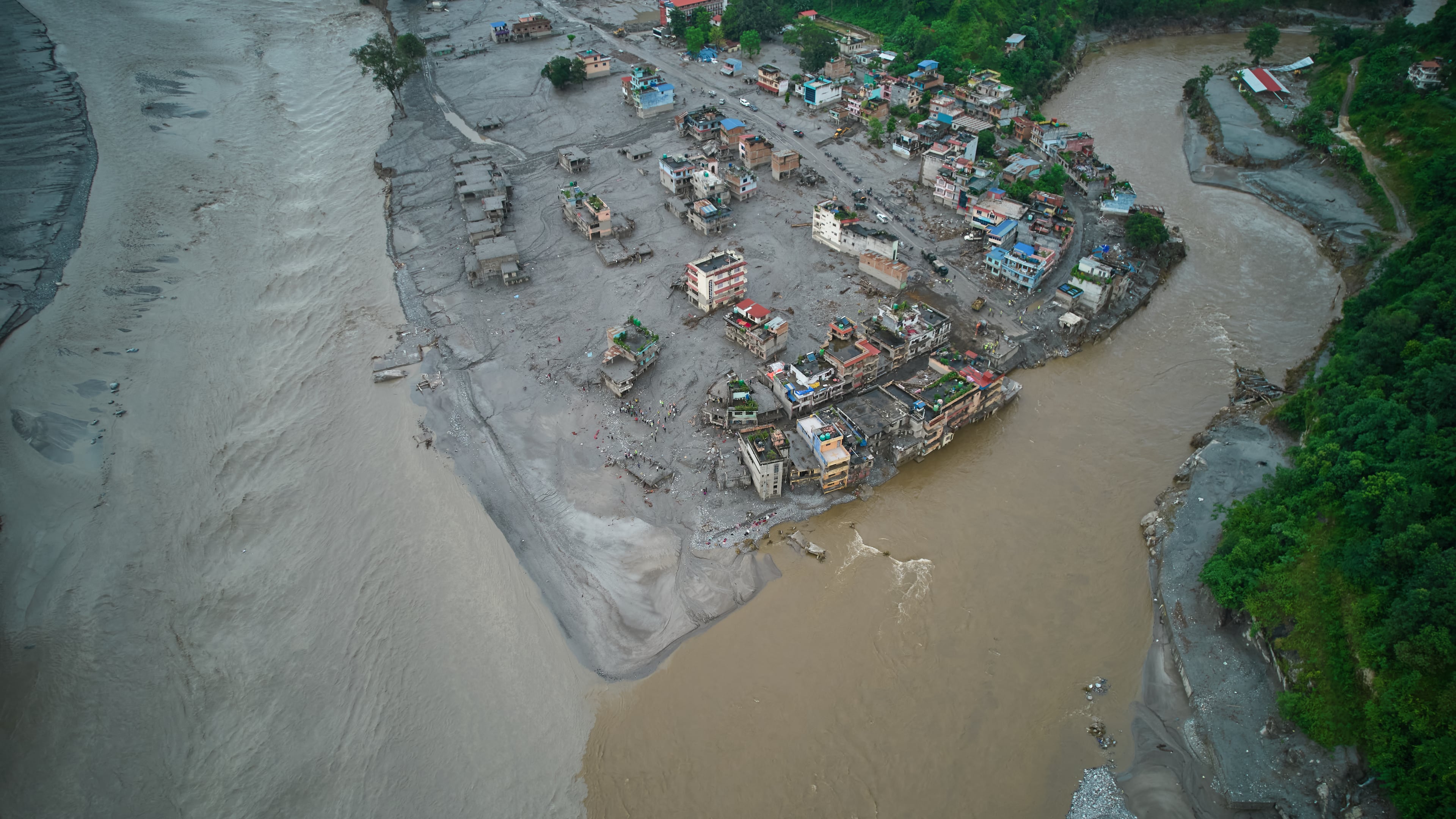 A drone view shows houses damaged by flash floods surrounded by sludge, mud and debris along the swollen Trishuli River in Devighat, Nepal, Thursday, Sept. 3, 2026. (AP Photo/Rajesh Kumar Singh)