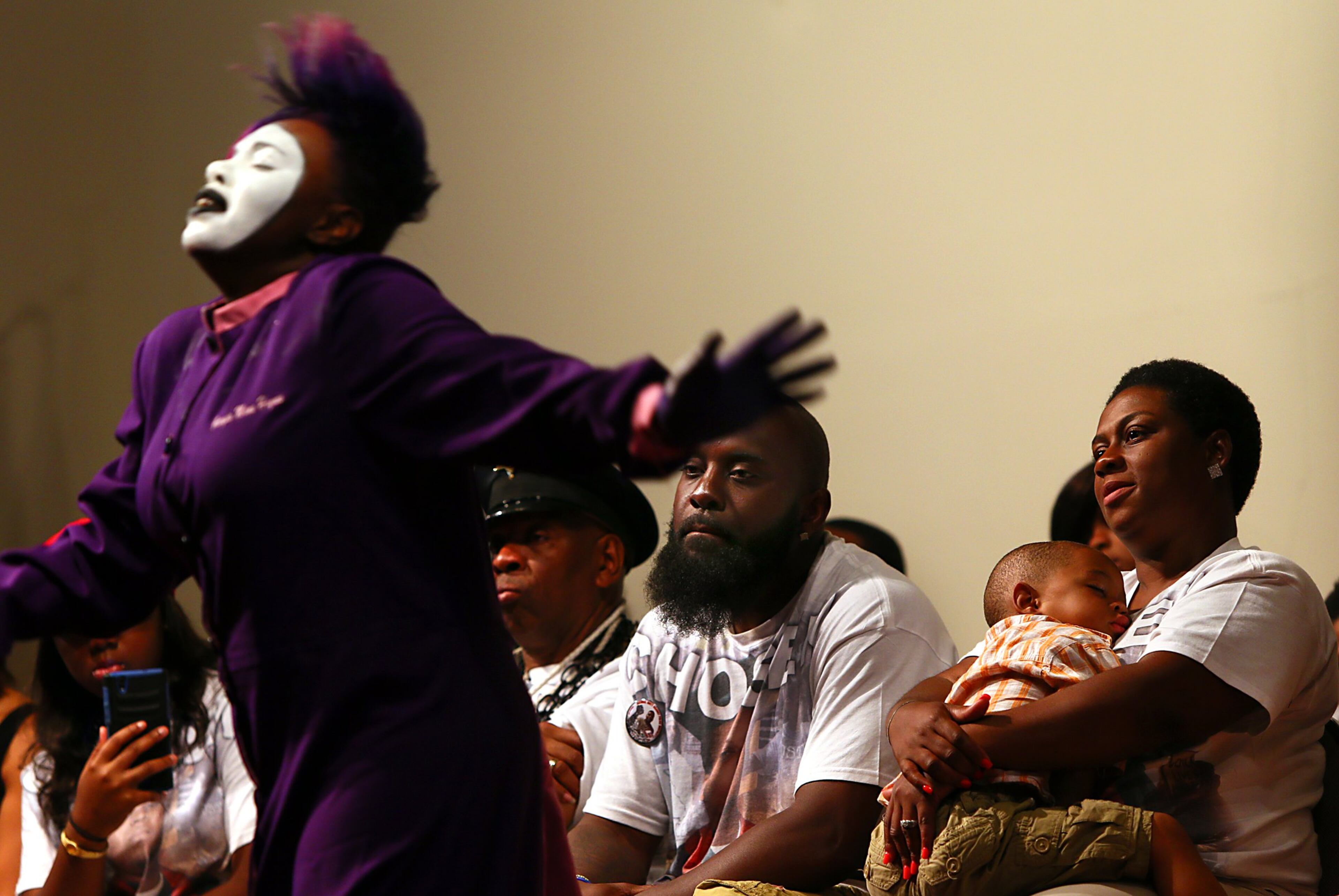 Georgia Haynes, of Mi Story Dance Company, performs near Michael Brown Sr., second from right, and his wife Calvina during a service at Greater St. Mark's Family Church, Sunday, Aug. 9, 2015, in St. Louis, a year after Brown's son, Michael Brown, was shot and killed by Ferguson, Mo., Police Officer Darren Wilson. (Robert Cohen/St. Louis Post-Dispatch via AP) EDWARDSVILLE INTELLIGENCER OUT; THE ALTON TELEGRAPH OUT; MANDATORY CREDIT