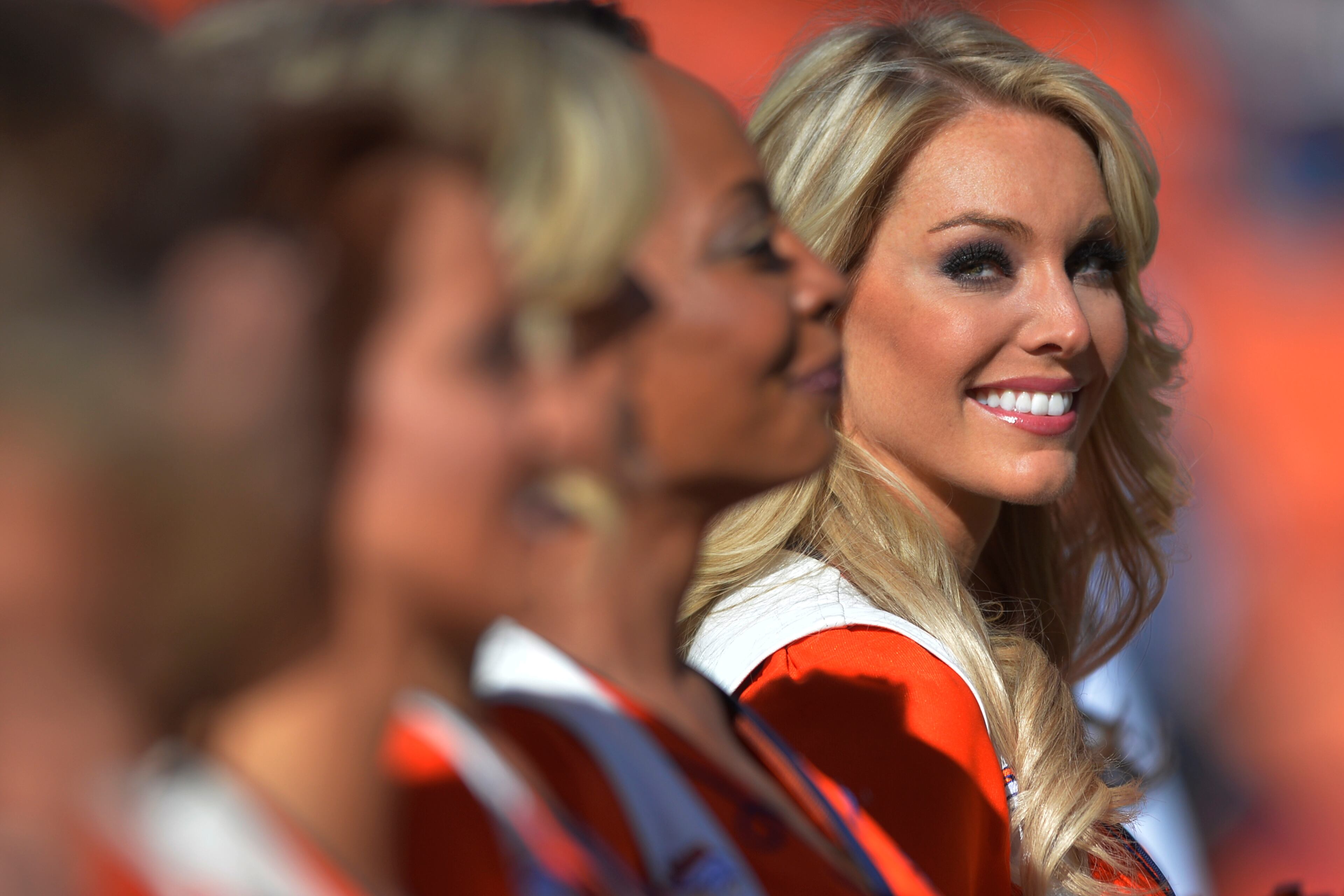 A Denver Broncos cheerleader watches the team introductions during the first half of an NFL football game against the New England Patriots in Denver on Jan. 19, 2014.