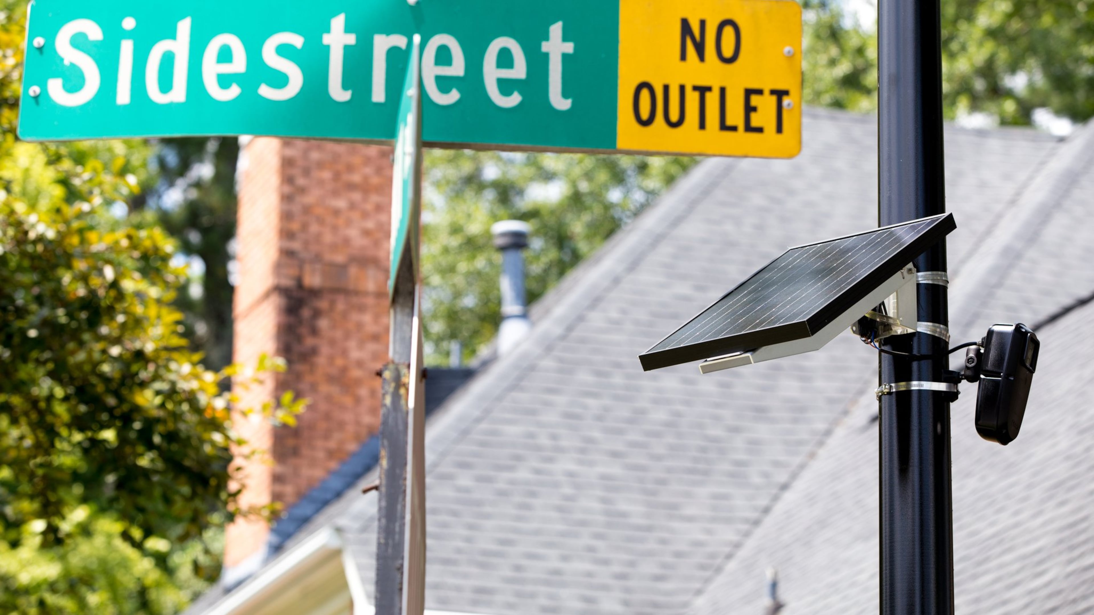 A Flock license plate reader, powered by a solar panel, is shown in the Sidestreet subdivision in Brookhaven in a 2020 file photo. The license plate reader takes a picture of each license plate that enters the neighborhood and keeps track of each vehicle’s comings and goings. (Casey Sykes for the AJC)