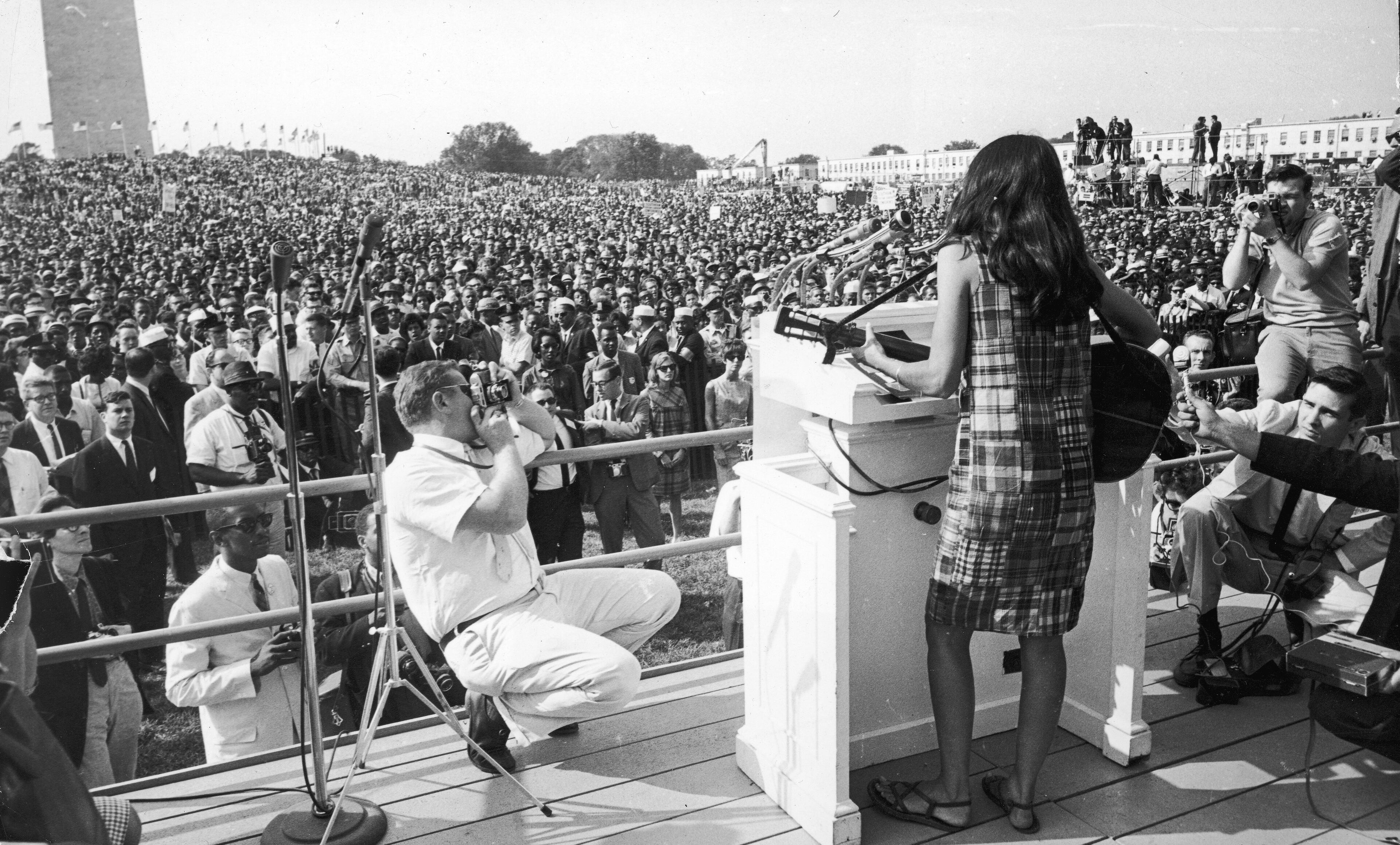 American folk singer and musician Joan Baez performs onstage for the crowd gathered on the Mall during the Civil Rights March on Washington, D.C., August 29, 1963. (Photo by Express Newspapers/Getty Images)