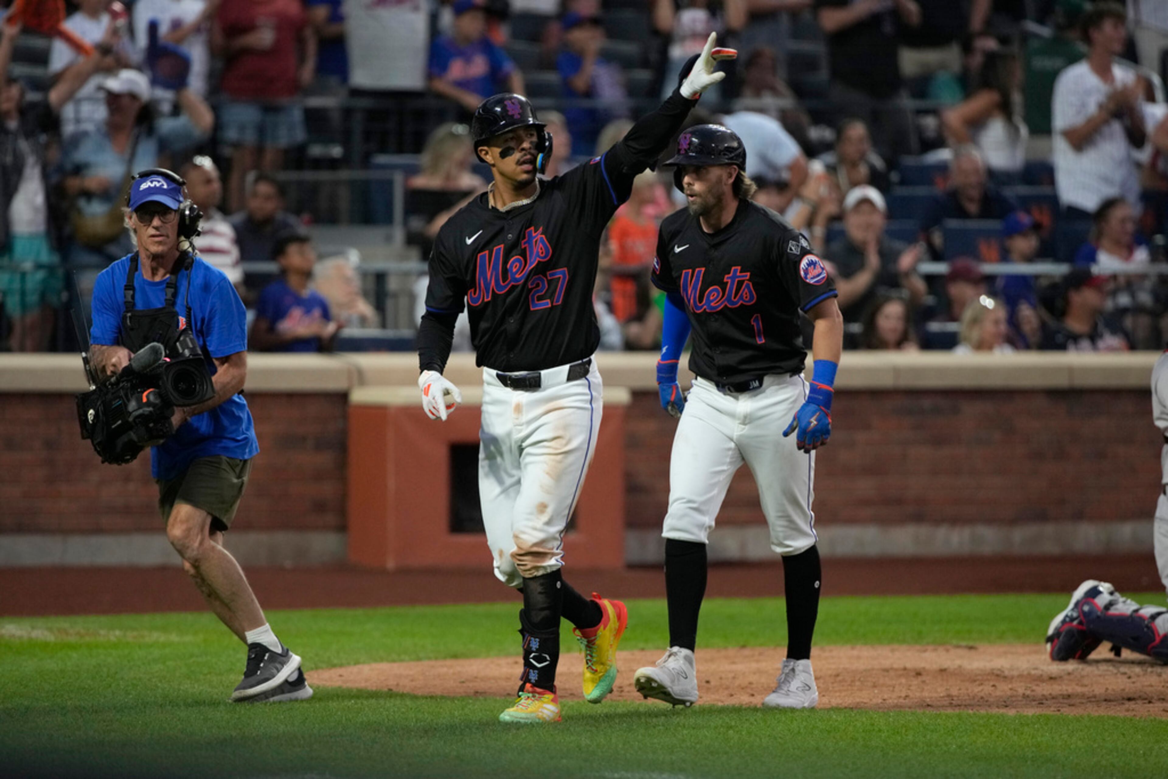 New York Mets' Mark Vientos, center, celebrates after hitting a home run scoring Jeff McNeil, right, during the third inning of a baseball game against the Atlanta Braves, Friday, July 26, 2024, in New York. (AP Photo/Pamela Smith)