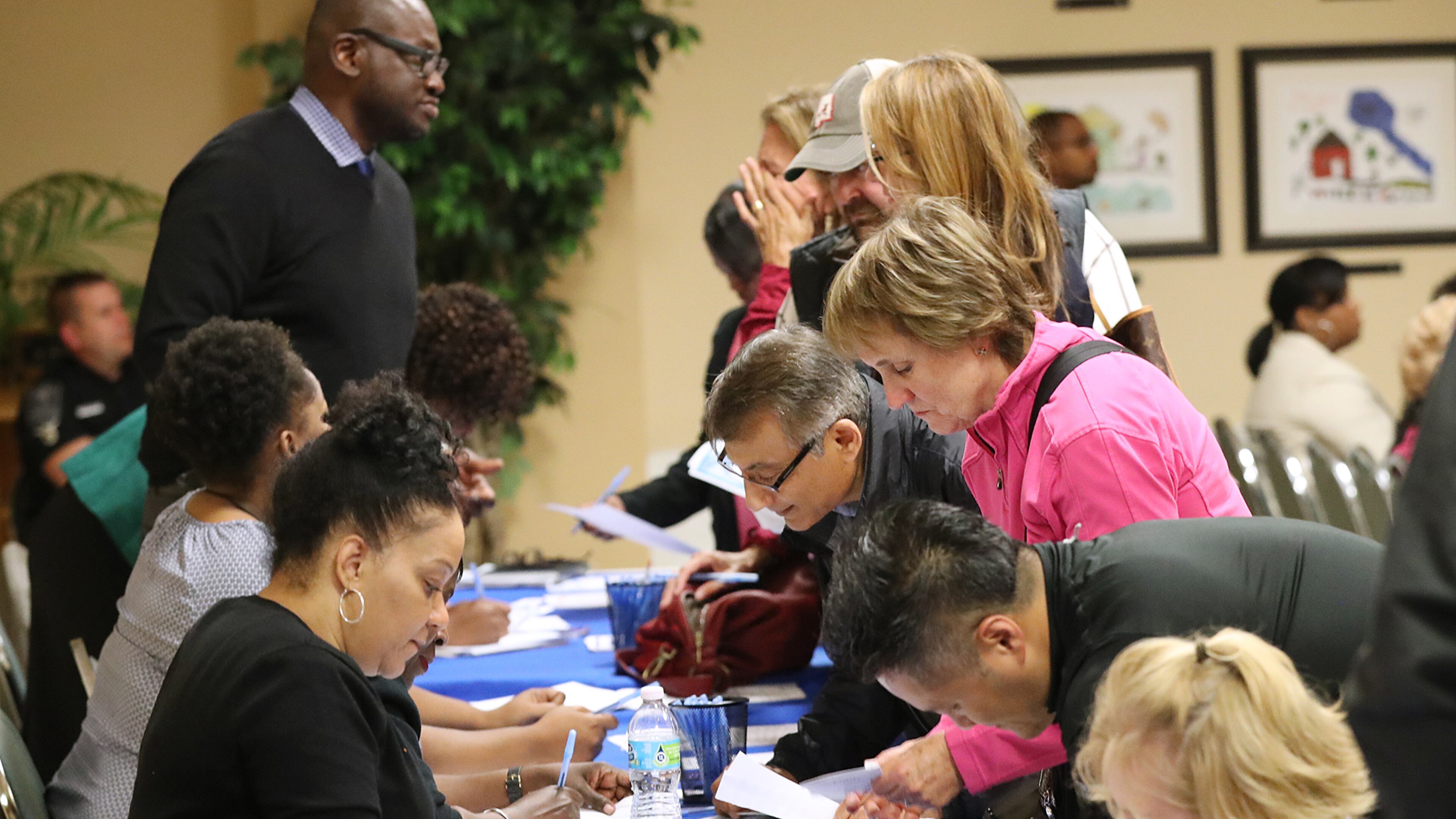 DeKalb residents fill a table seeking answers about excessively high water bills during a town hall meeting at the Maloof Auditorium in Decatur on Nov. 10. Curtis Compton/ccompton@ajc.com