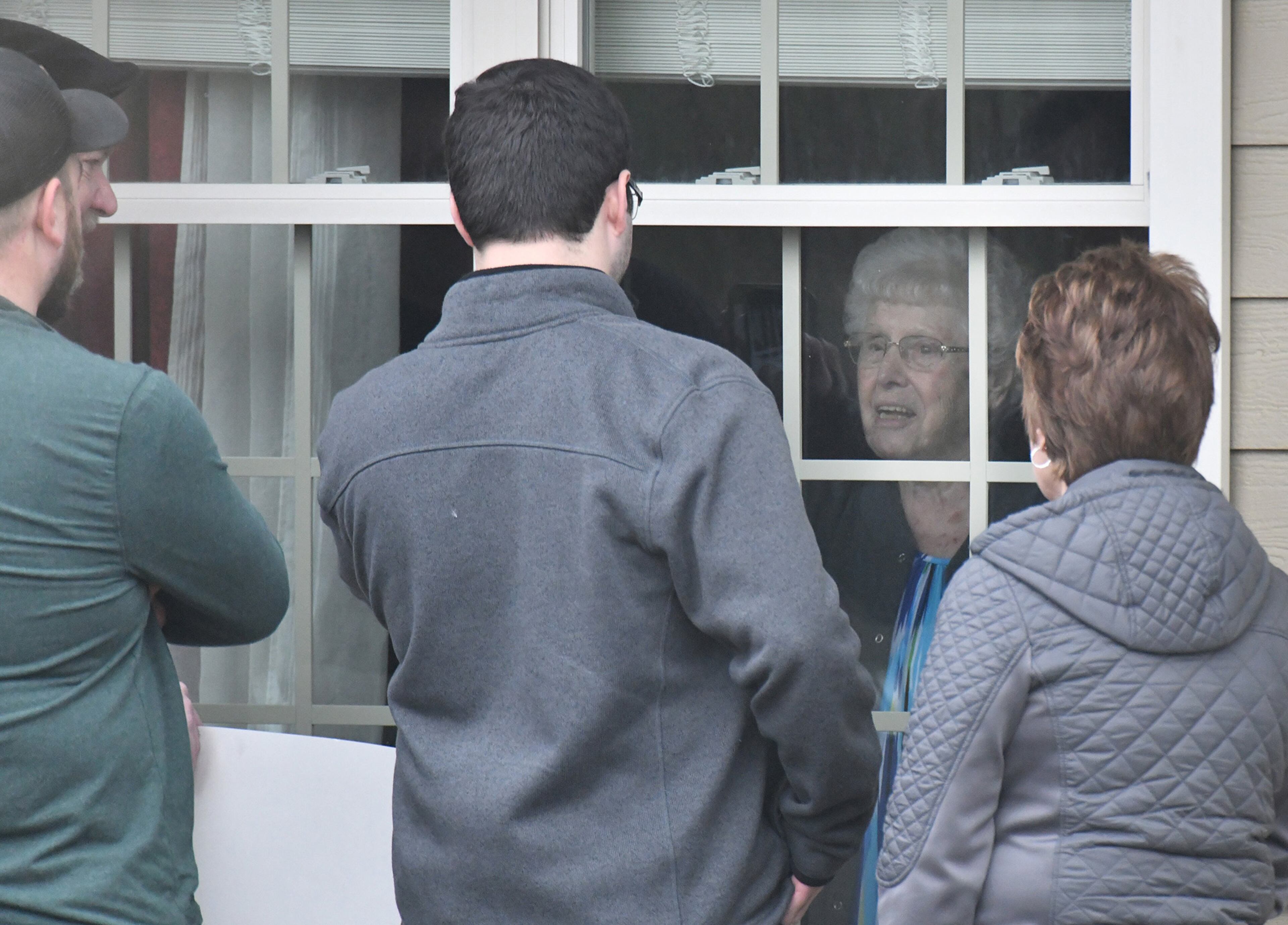 March17, 2020 Canton - Family members visit an elderly family member thru the window after they delivered a birthday balloon and a gift bag at The Retreat at Canton, where confirmed that three residents and an employee have "tested presumptively positive" for COVID-19, on Tuesday, March 17, 2020. The Retreat at Canton confirmed that three residents and an employee have "tested presumptively positive" for COVID-19, according to a release by the facility that has 90 beds. (Hyosub Shin / Hyosub.Shin@ajc.com)