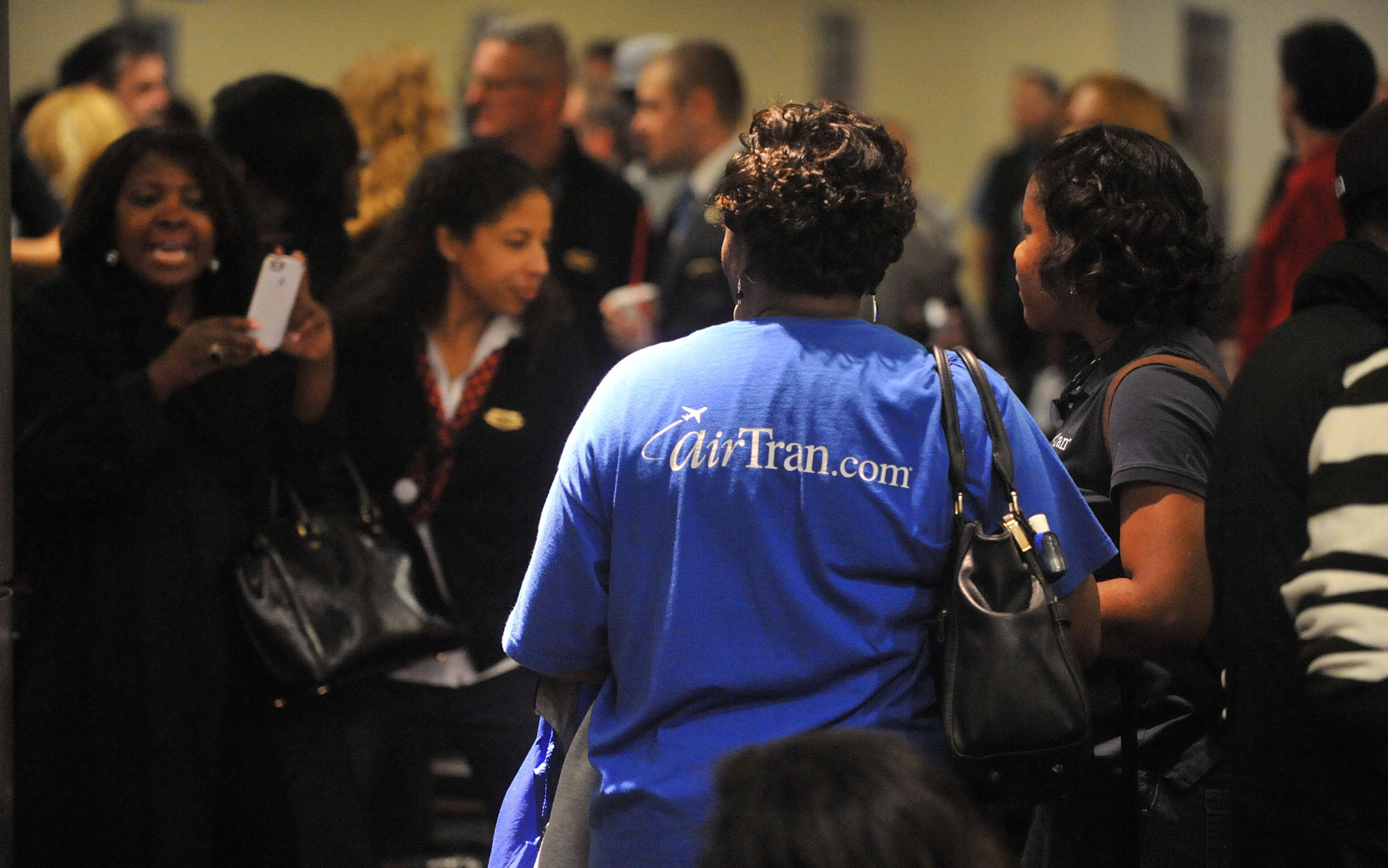 Hundreds of Southwest Airlines and former AirTran Airways employees gathered at Concourse C, gates 1, 2 and 3 to celebrate the departure of AirTran’s final flight to Tampa FL, at Hartsfield-Jackson International Airport, Sunday, December 28, 2014. Southwest CEO Gary Kelly and executives Bob Jordan and Jack Smith gave remarks during the program. The full flight was waved off by employees that gathered on the tarmac as crash trucks from Atlanta Fire Rescue gave a final water cannon salute as the plane departed. KENT D. JOHNSON/KDJOHNSON@AJC.COM