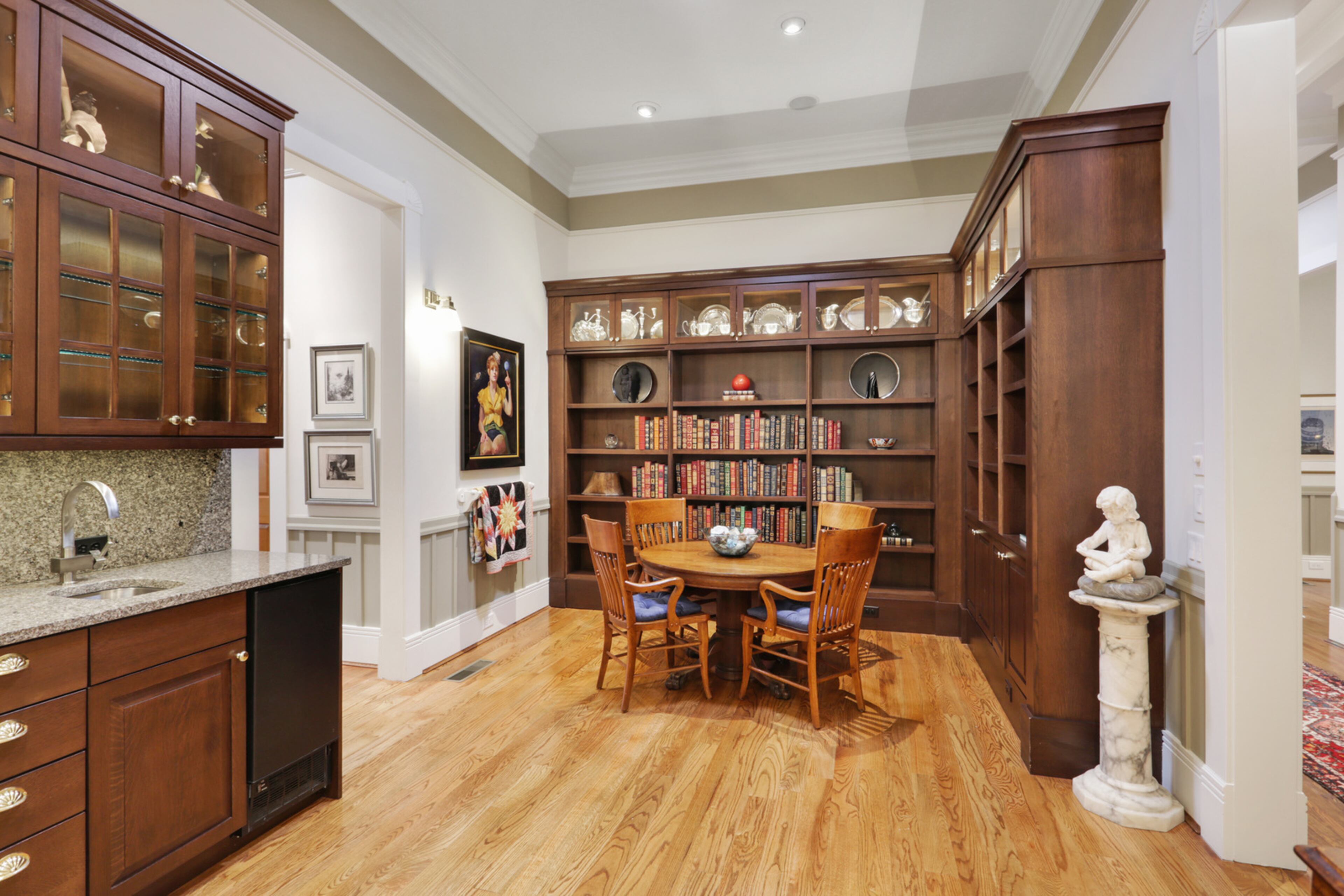 The study, which looks into the kitchen and den, boasts custom shelving for more art and books. All the openings throughout the house are gracious. Text by Jill Huitron