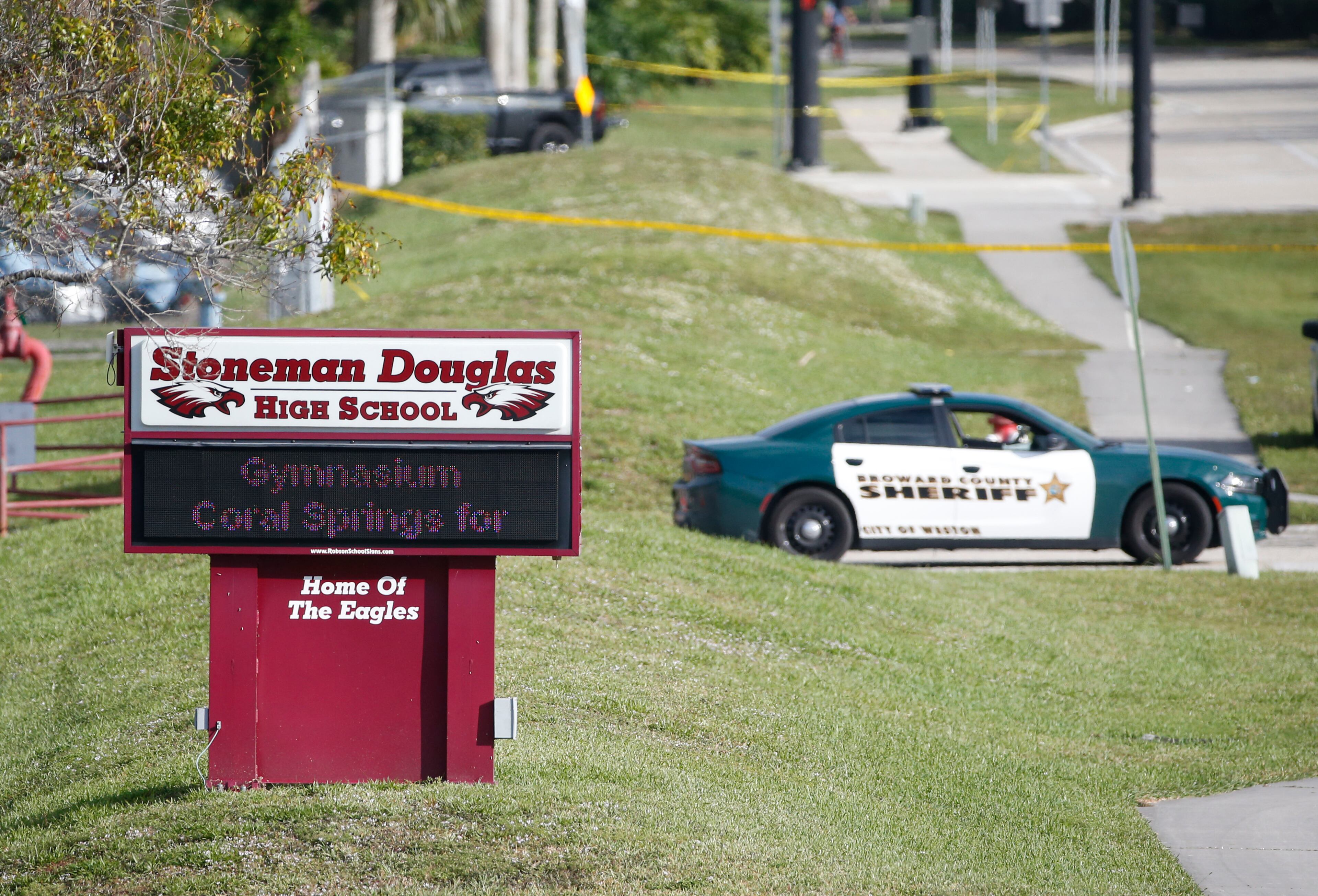 Law enforcement officers block off the entrance to Marjory Stoneman Douglas High School, Thursday, Feb. 15, 2018 in Parkland, Fla. Nikolas Cruz was charged with 17 counts of premeditated murder on Thursday, the day after opening fire with a semi-automatic weapon at the school. (AP Photo/Wilfredo Lee)