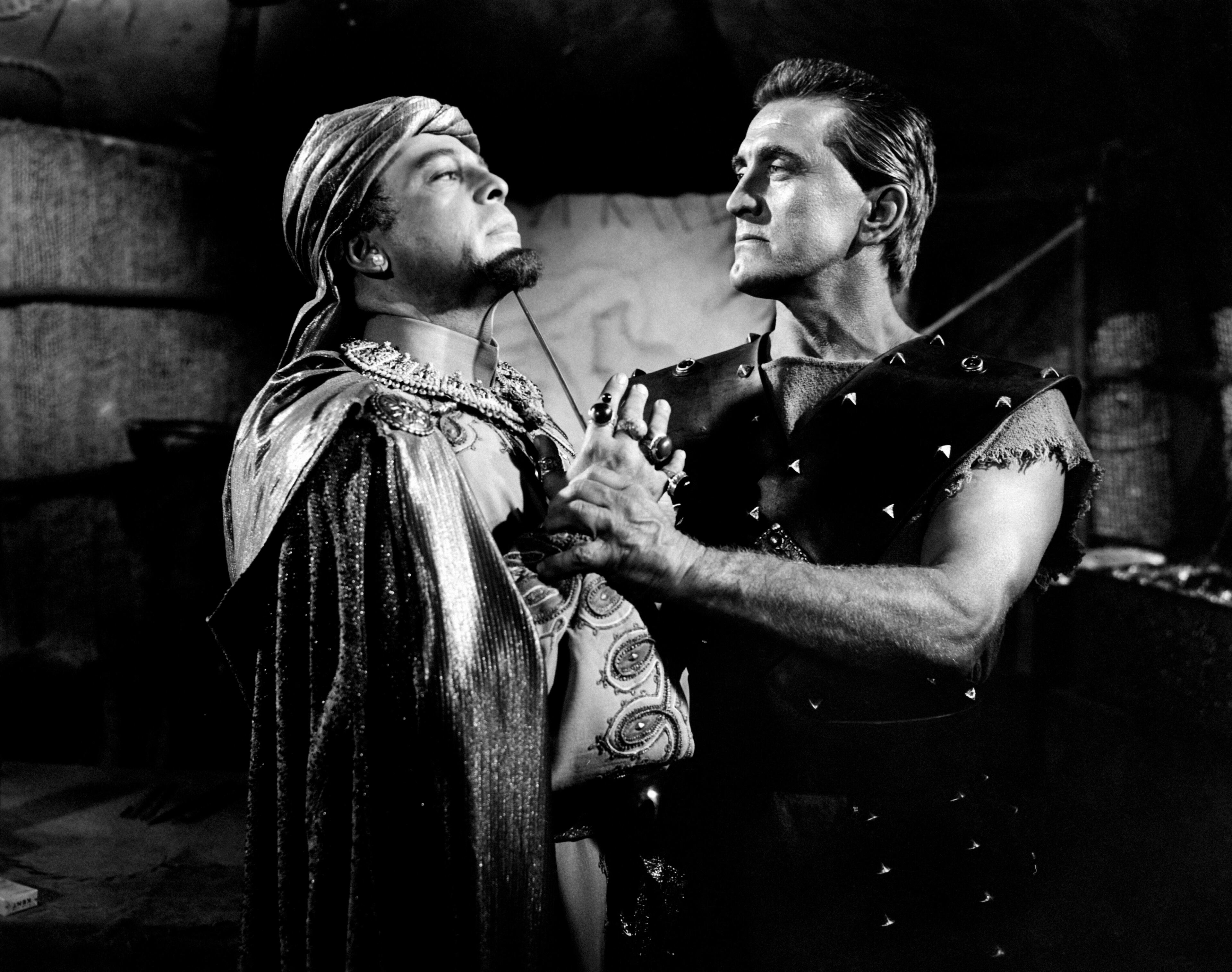 1959: American actor Kirk Douglas pointing a dagger at the throat of the Czech actor Herbert Lom (Herbert Karel Angelo Kuchacevicze Schluderpacheru) in the film Spartacus. (Photo by Mondadori Portfolio via Getty Images)