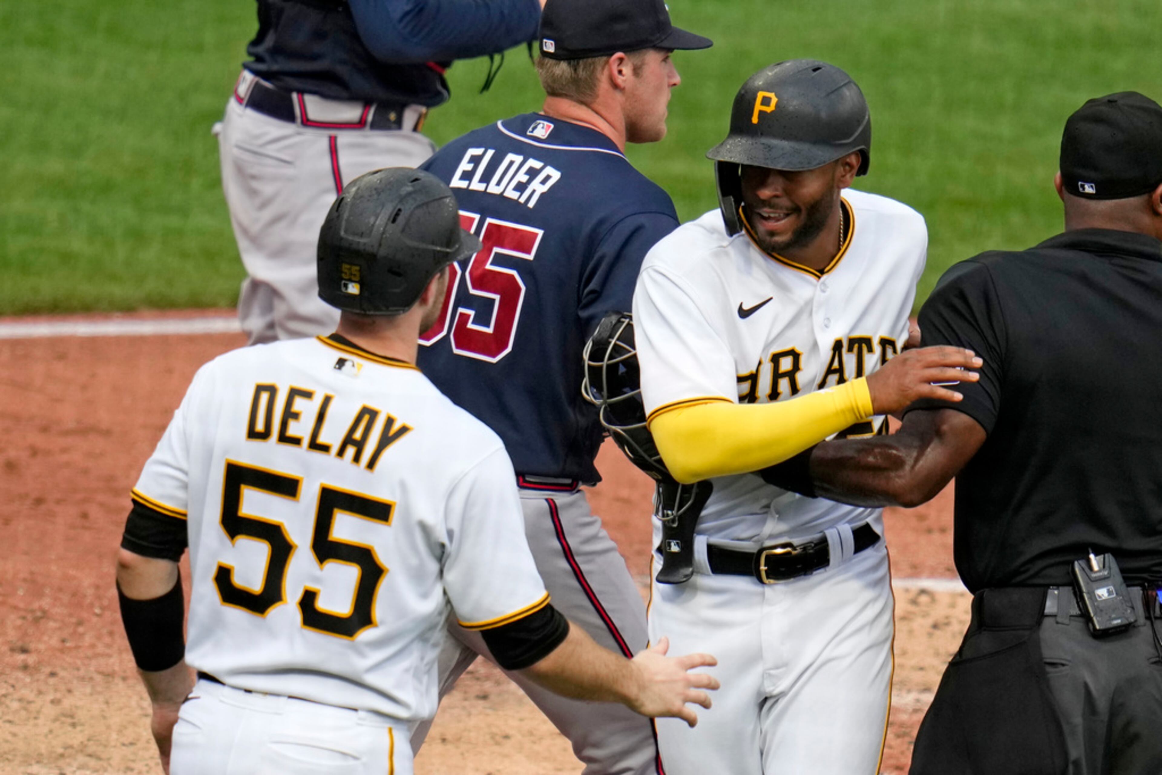Pittsburgh Pirates' Josh Palacios, second from right, is greeted by Jason Delay (55), as he runs into umpire Alan Porter, right, after scoring the second run on a single by Ke'Bryan Hayes off Atlanta Braves starting pitcher Bryce Elder, center, during the third inning of a baseball game in Pittsburgh, Thursday, Aug. 10, 2023. (AP Photo/Gene J. Puskar)