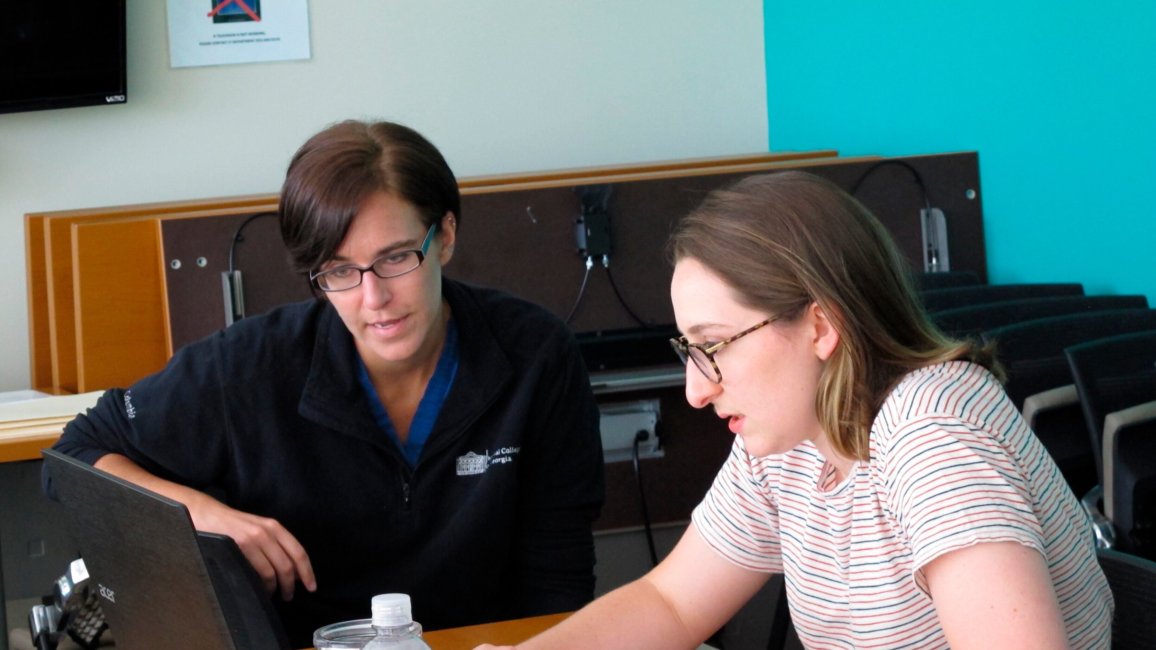 Medical students Rebecca DeCarlo, left, and Melissa Easley work at the Georgia Department of Public Health’s district office in Savannah on April 22, 2020. They are among about 30 medical students helping the Georgia health agency’s coastal district with contact tracing aimed at identifying relatives, friends and co-workers of people infected by the virus to prevent its spread to others. (AP Photo/Russ Bynum)