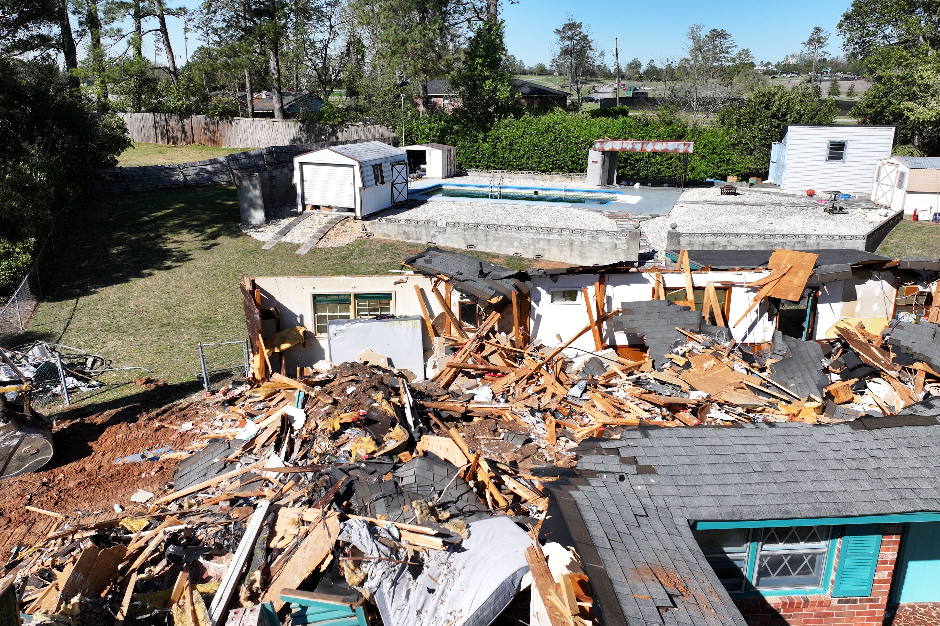 Arial photo shows damaged house as parking lots of Augusta National Golf Club are shown in background, Tuesday, March 25, 2025, in Augusta. Six months after Hurricane Helene, Augusta-area community is still working to recover from the extensive damage. (Hyosub Shin / AJC)