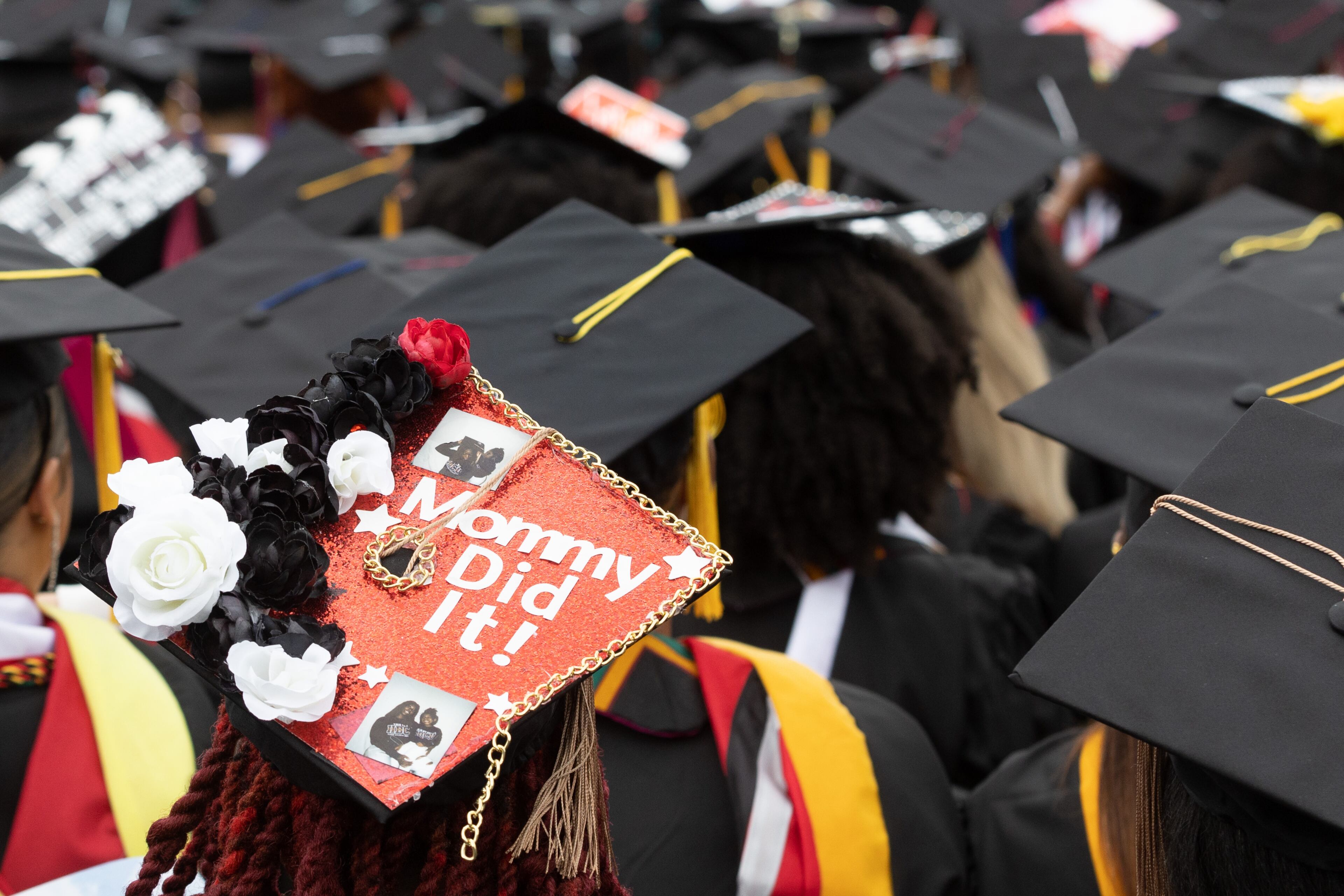 Graduates - including one with a message for mom - wait for the Clark Atlanta University commencement ceremony to start in Panther Stadium on Saturday, May 20, 2023. (Steve Schaefer/steve.schaefer@ajc.com)