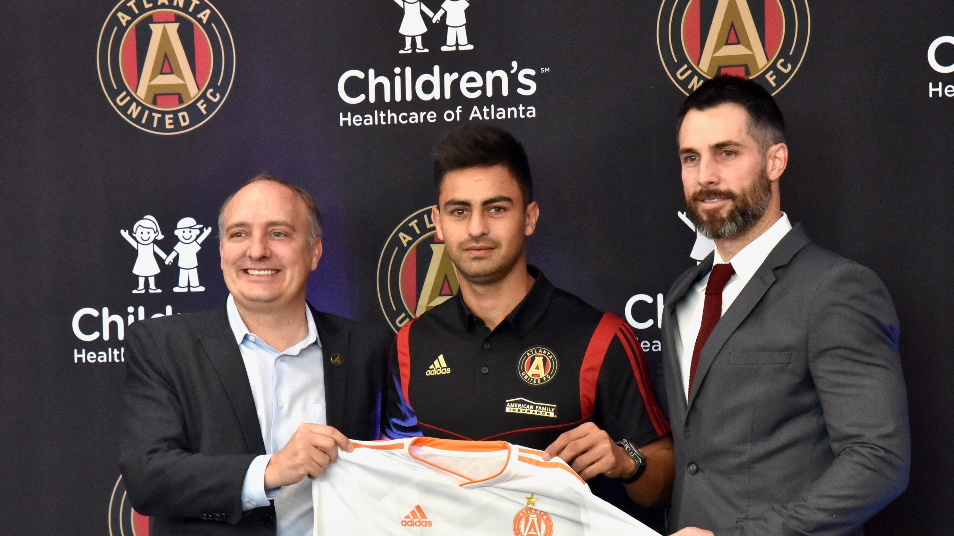 Atlanta United's newest signing, Pity Martinez (center), poses with team president Darren Eales (left) and Carlos Bocanegra (right) on Friday at the team's training ground in Marietta. (Hyosub Shin / AJC)