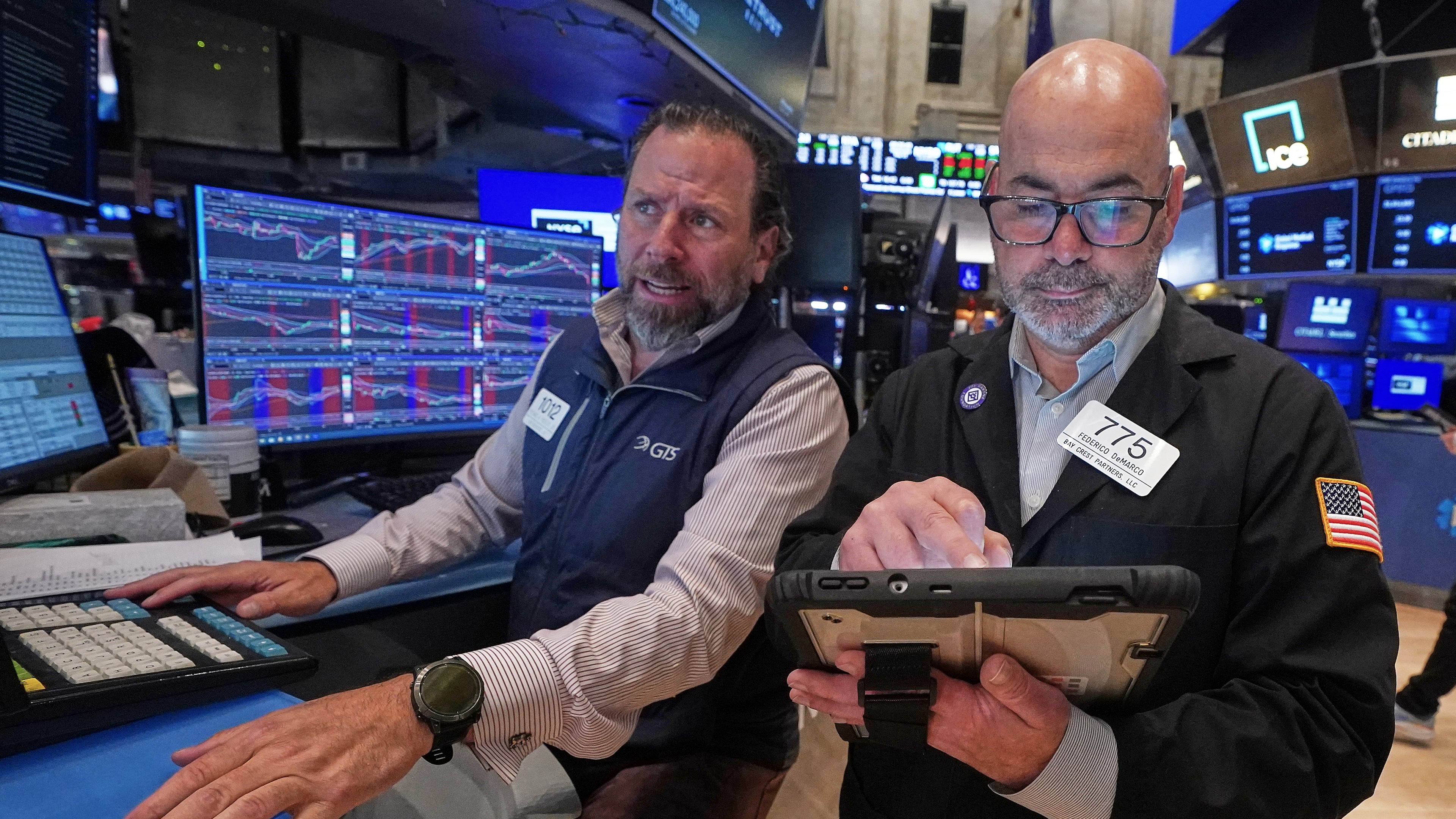 Specialist Michael Pistillo. Left, and trader Fred's Demarco work on the floor of the New York Stock Exchange, Wednesday, May 13, 2026. (AP Photo/Richard Drew)