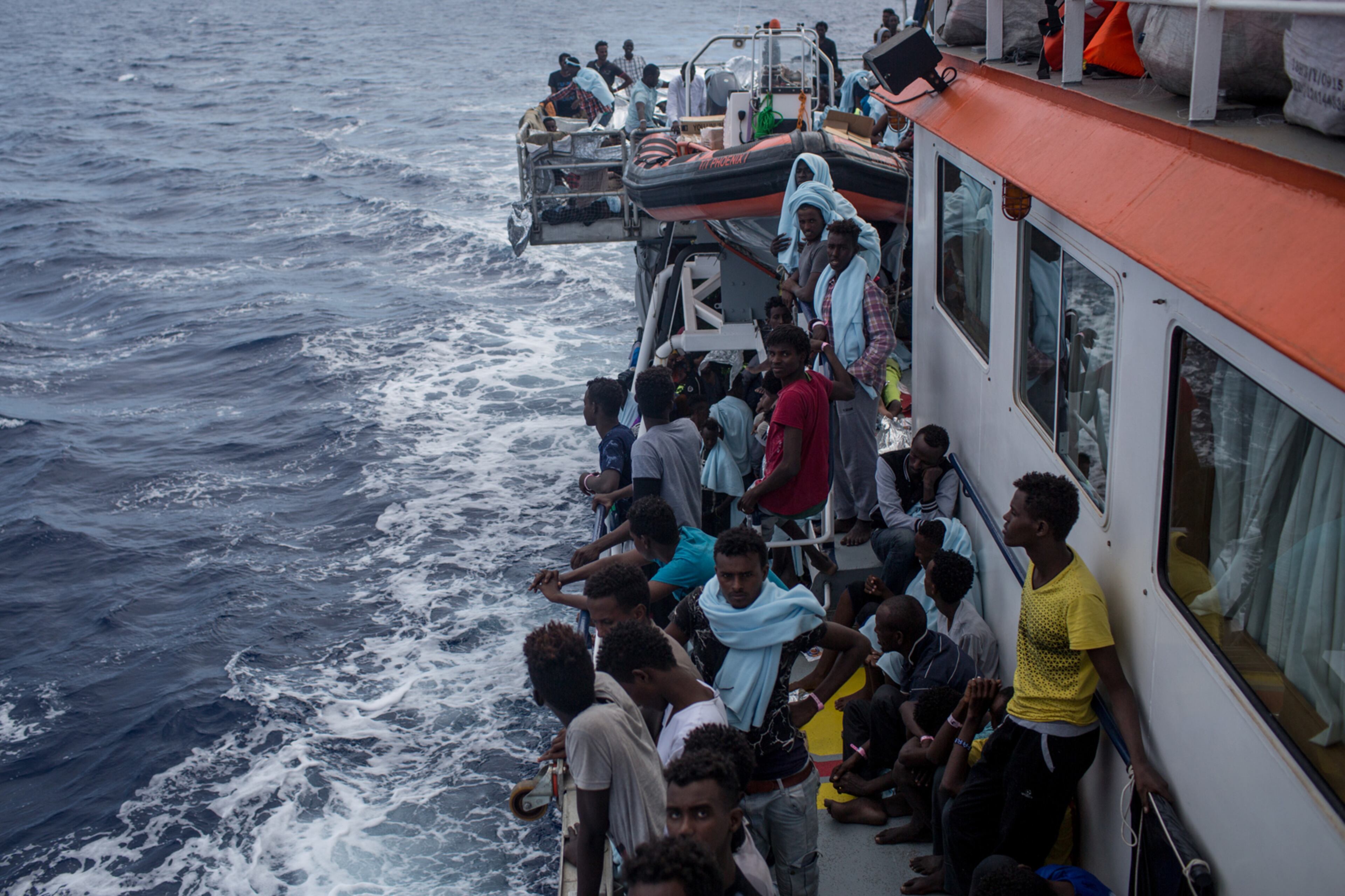 LAMPEDUSA, ITALY - MAY 25: Refugees and migrants rest on board the Migrant Offshore Aid Station (MOAS) 'Phoenix' vessel on May 25, 2017 off Lampedusa, Italy. The crew of the 'Phoenix' rescued 603 people yesterday after one of three wooden boats partially capsized leaving more than 30 people dead. Numbers of refugees and migrants attempting the dangerous central Mediterranean crossing from Libya to Italy has risen since the same time last year with more than 43,000 people recorded so far in 2017. In an attempt to slow the flow of migrants Italy recently signed a deal with Libya, Chad and Niger outlining a plan to increase border controls and add new reception centers in the African nations, which are key transit points for migrants heading to Italy. MOAS is a Malta based NGO dedicated to providing professional search-and-rescue assistance to refugees and migrants in distress at sea. Since the start of the year MOAS have rescued and assisted 3572 people and are currently patrolling and running rescue operations in international waters off the coast of Libya. (Photo by Chris McGrath/Getty Images)