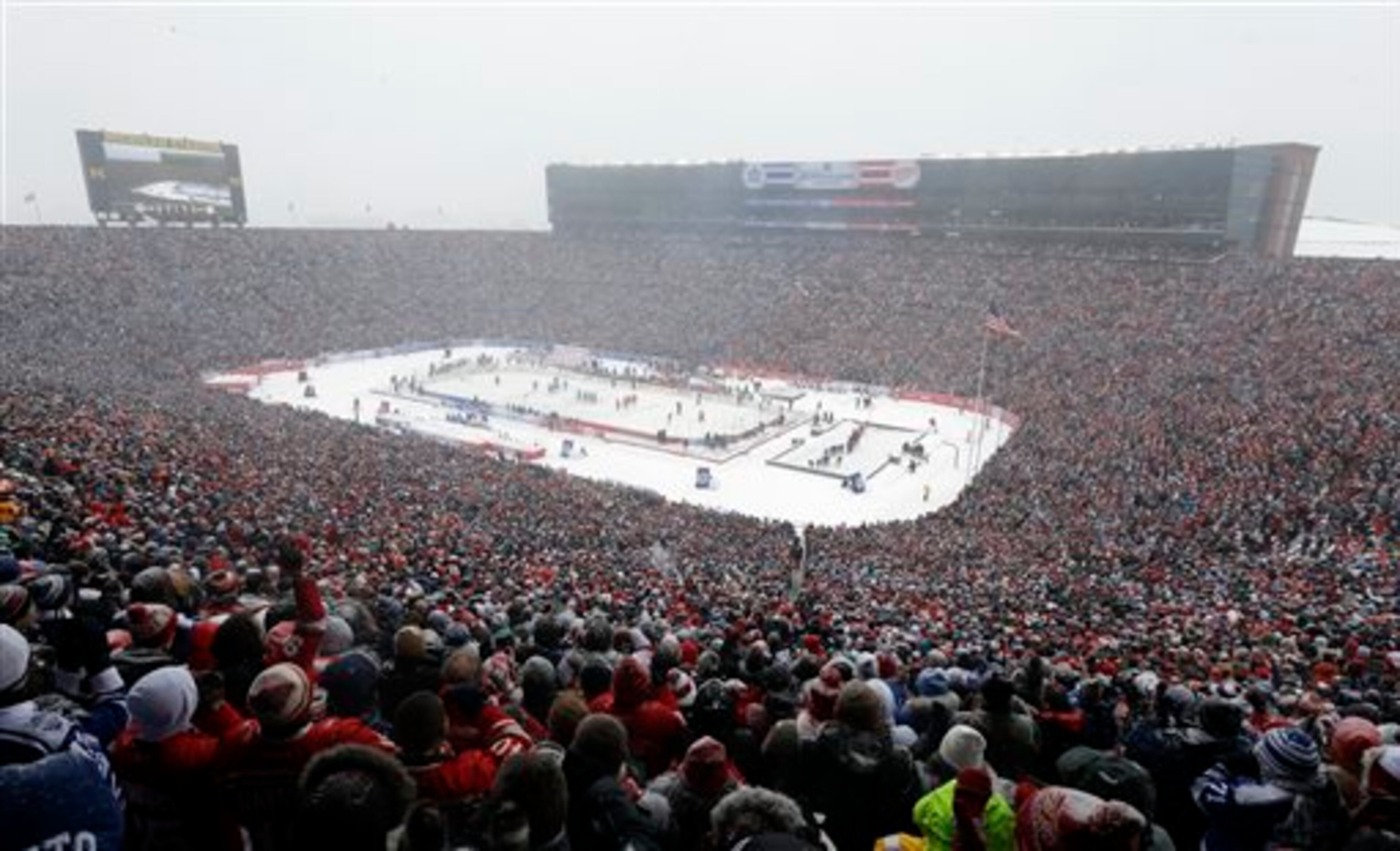 Hockey fans stand during the national anthems before the Winter Classic outdoor NHL hockey game between of the Toronto Maple Leafs and the Detroit Red Wings at Michigan Stadium in Ann Arbor, Mich., Wednesday, Jan. 1, 2014. (AP Photo/Carlos Osorio)