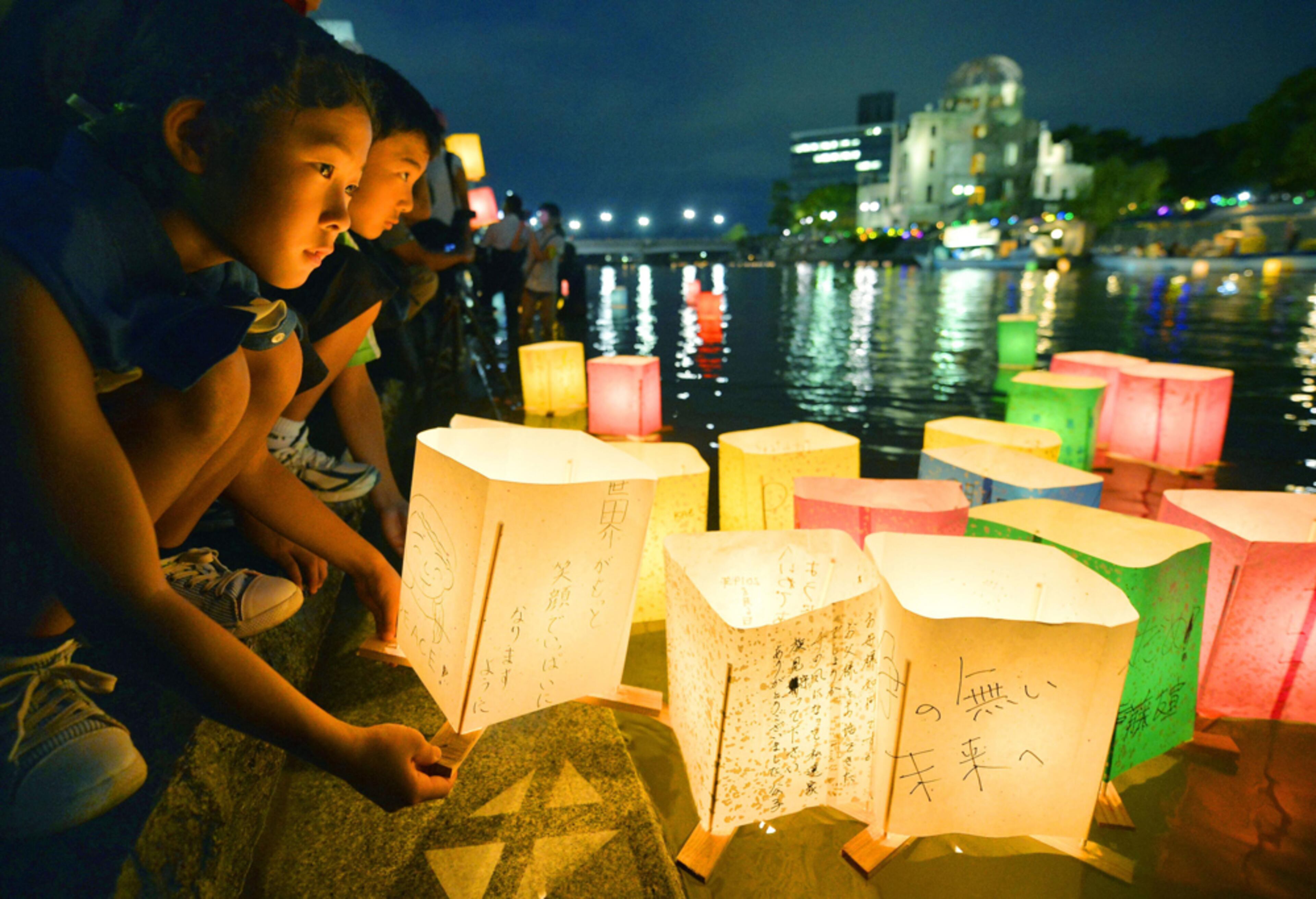 HIROSHIMA BOMB ANNIVERSARY--A girl prepares to release paper lanterns with a message for peace on it in the Motoyasu River near the Atomic Bomb Dome in Hiroshima, western Japan, Wednesday, Aug. 6, 2014. Japan marked the 69th anniversary Wednesday of the atomic bombing of Hiroshima. (AP Photo/Kyodo News)