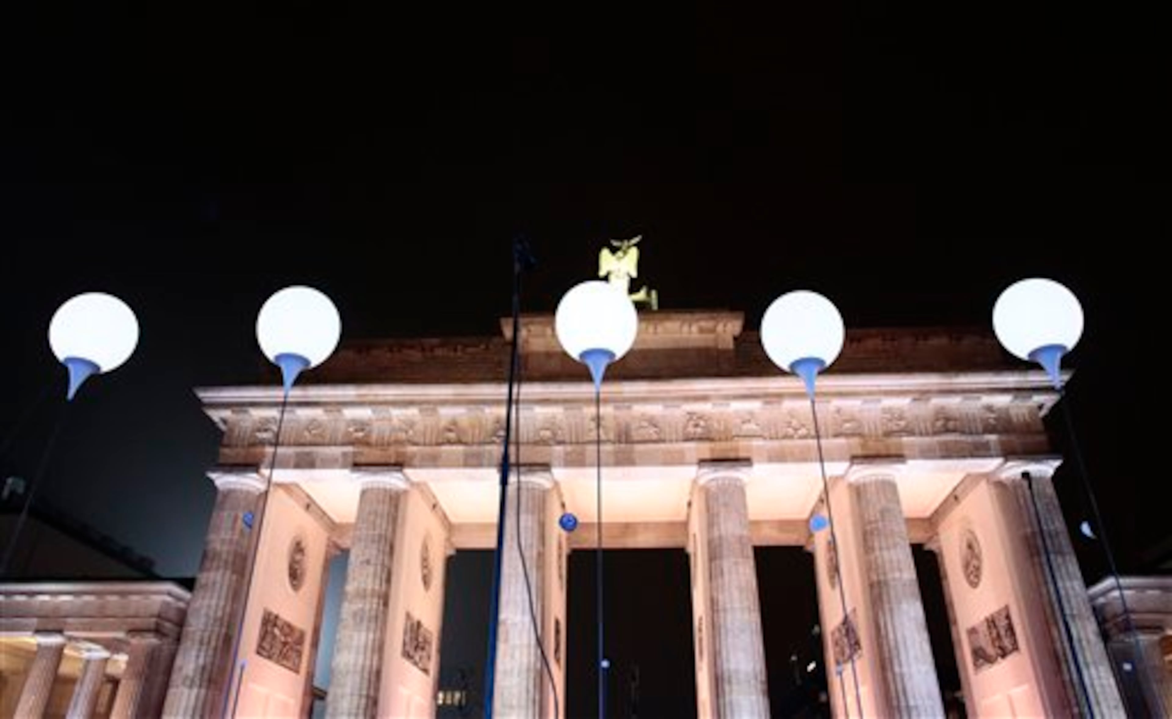 Balloons of the light installation Lichtgrenze 2014 (light border 2014) sit in front of Brandenburg Gate during the central event to commemorate the Fall of the Wall in Berlin, Germany, Sunday, Nov. 9, 2014. The 25th anniversary of the fall of the wall on Nov. 9, 1989 is marked with numerous events on the weekend. (AP Photo/Markus Schreiber)