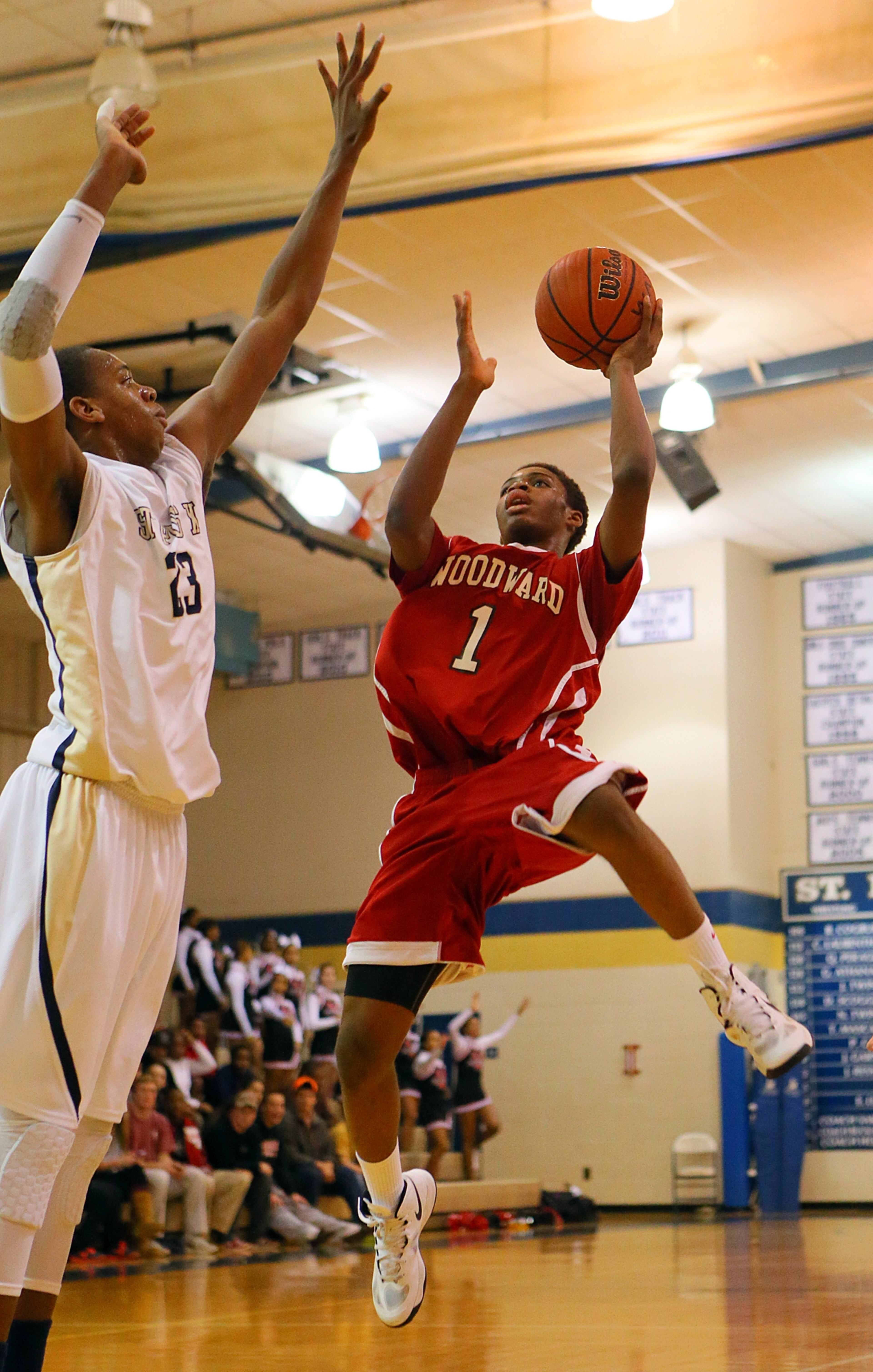 St. Pius defender Nick Harris (left) stretches to block a shot attempt by Woodward's Corey Hicks.