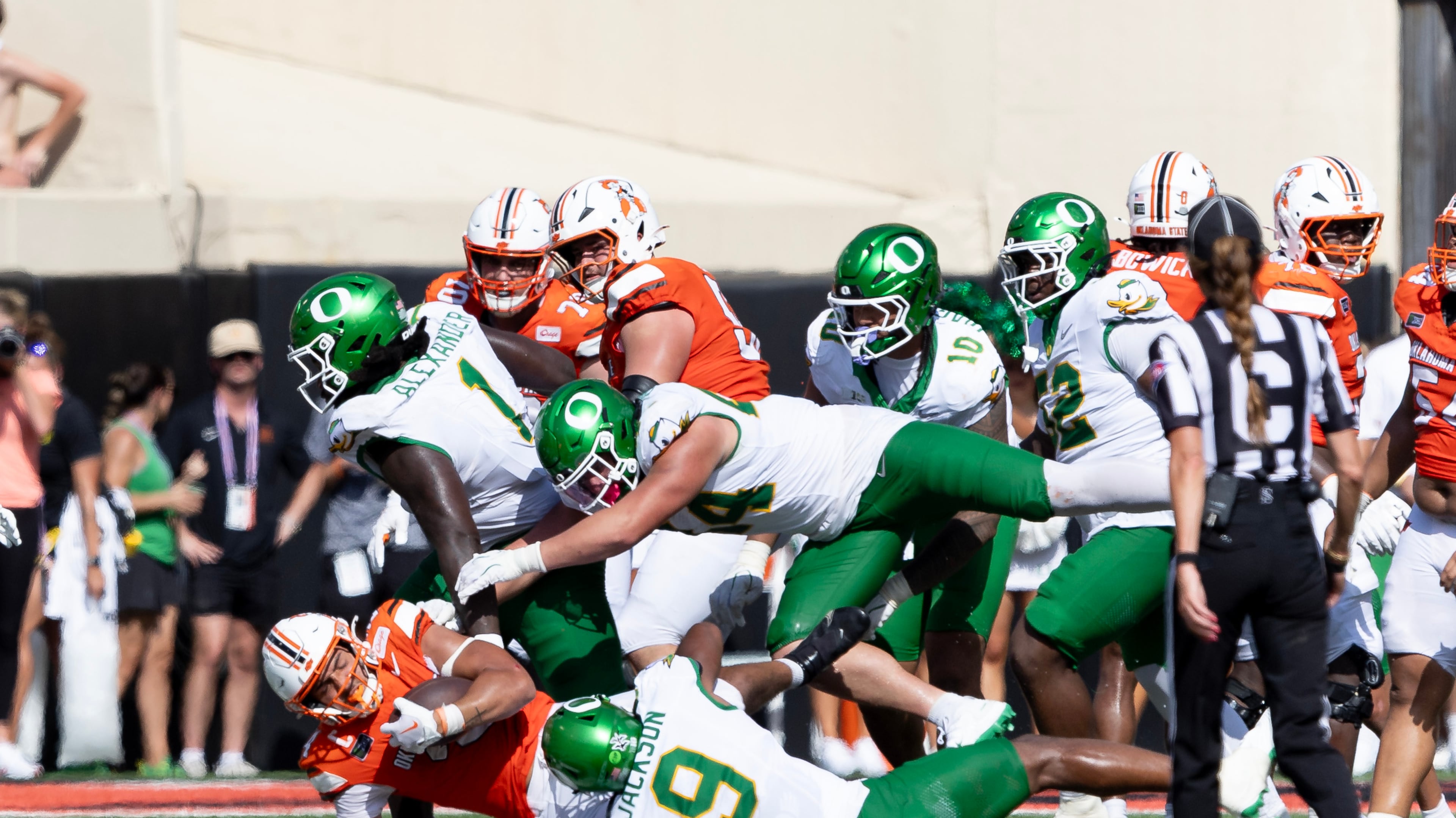 Oklahoma State running back Caleb Hawkins (24) is tackled by Oregon linebacker Devon Jackson (9), linebacker Teitum Tuioti (44) and Bear Alexander in the second half of the NCAA college football game in Stillwater, Okla., Saturday, Sept. 12, 2026. (AP Photo/Mitch Alcala)